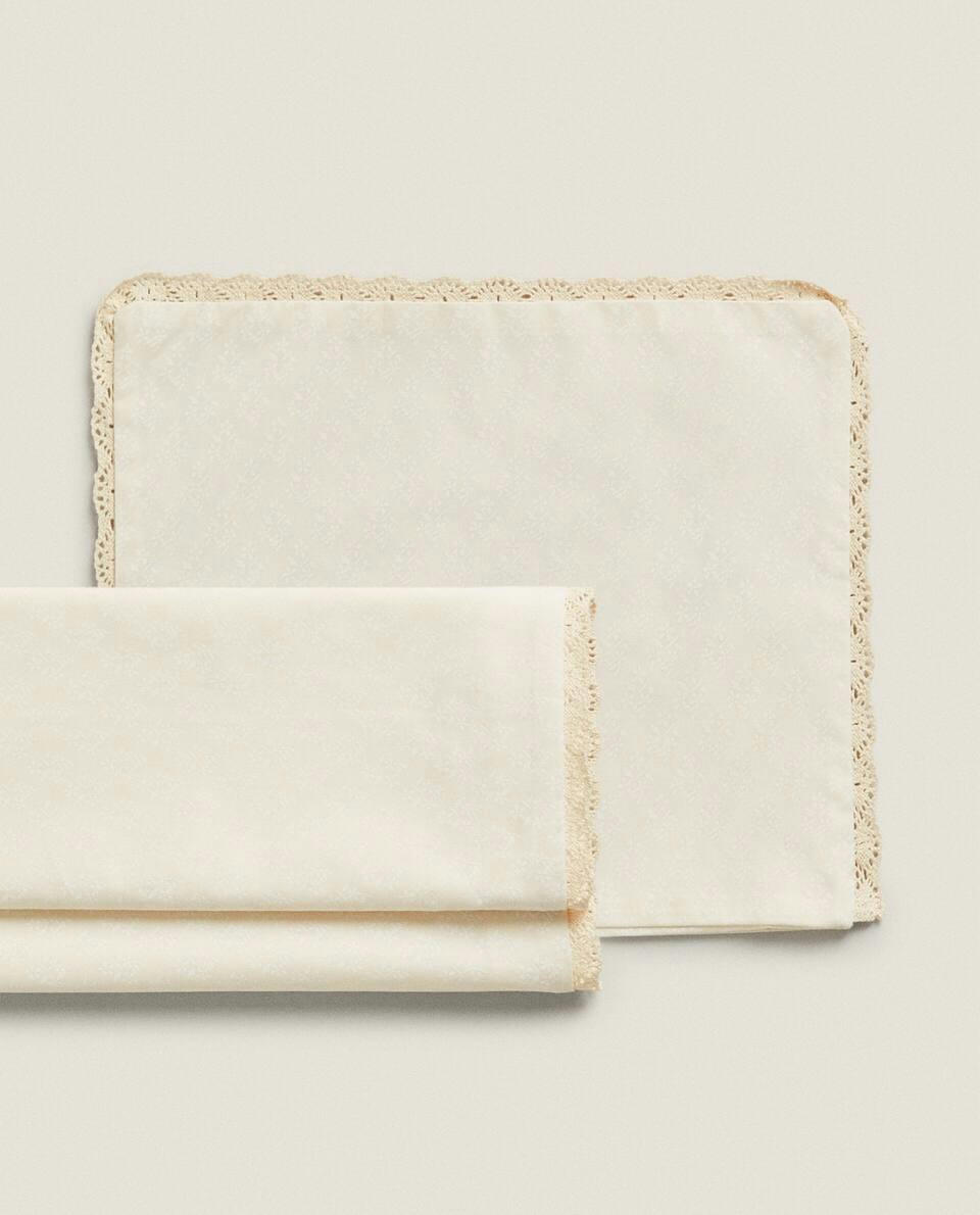 Conjunto de capa de edredom e fronha infantil com acabamento em renda.