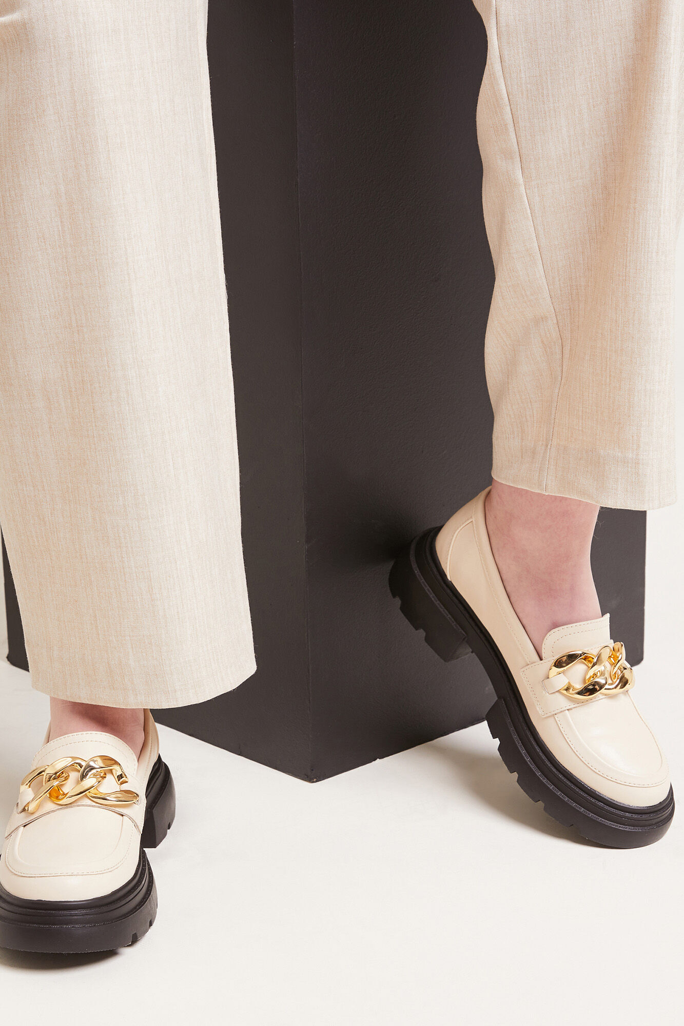 Mocassins robustos com fivelas douradas em imitação de couro.