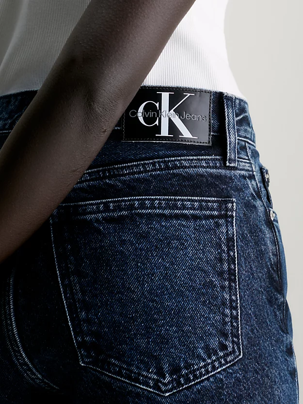 Calça jeans boca de sino com fenda na barra.
