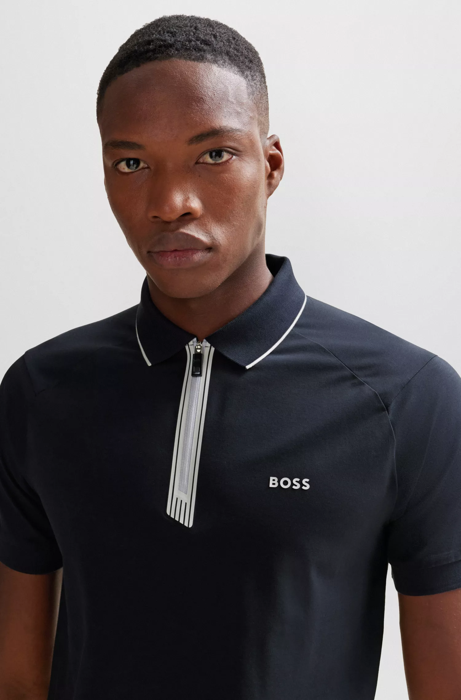 Camisa polo BOSS verde, de algodão stretch, corte slim, com fecho de zíper.