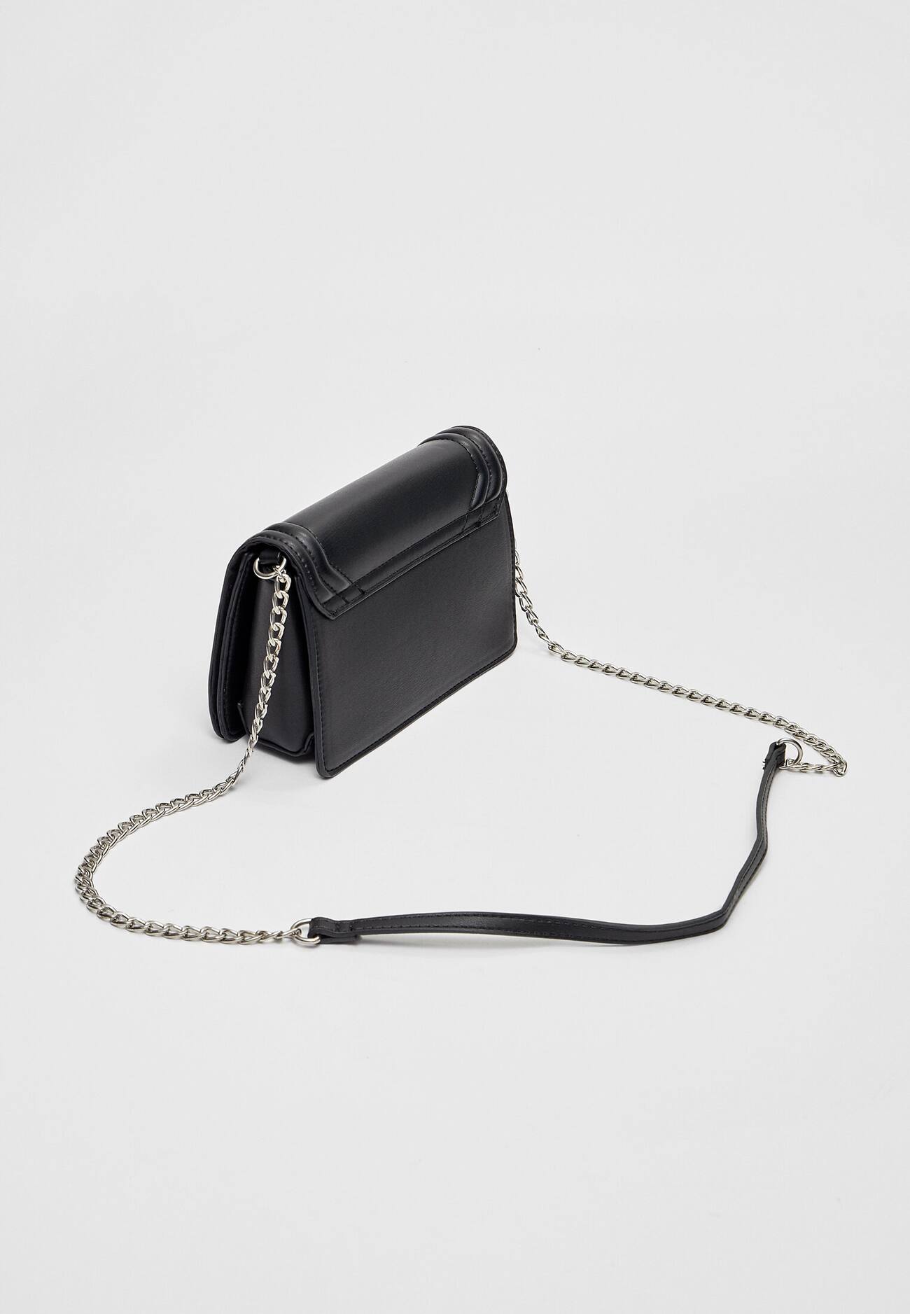 Bolsa transversal com detalhes em metal.