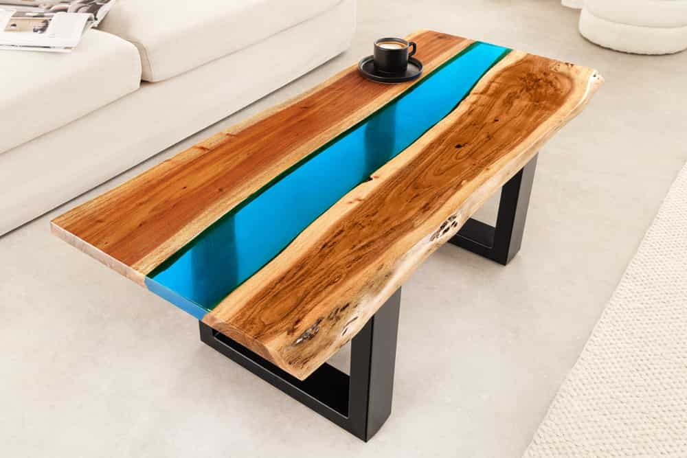 Massiver Couchtisch LIQUID 110cm braun Akazienholz Baumkante schwarz Eisen blau