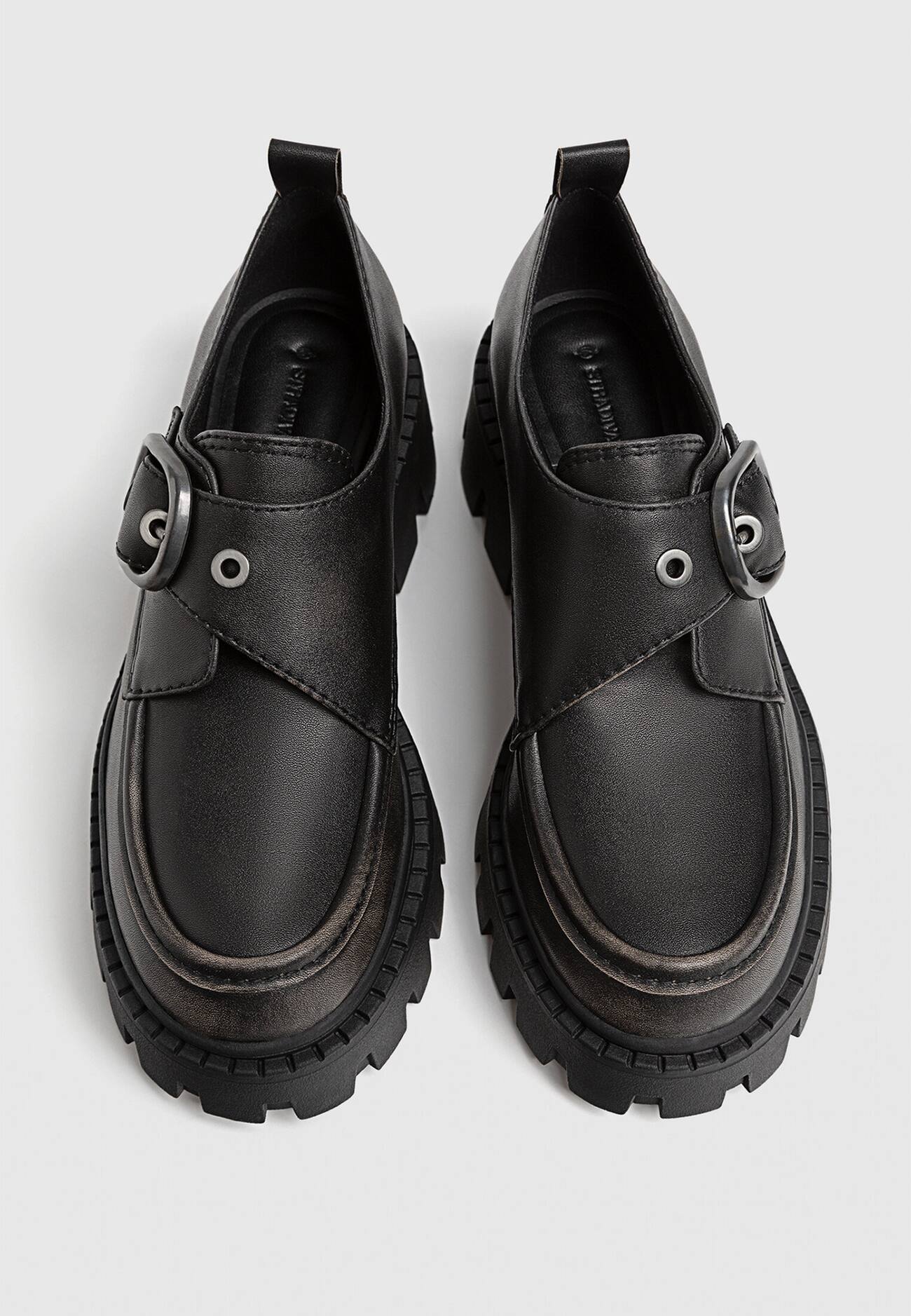 Sapatos baixos com fivela e solado tratorado.