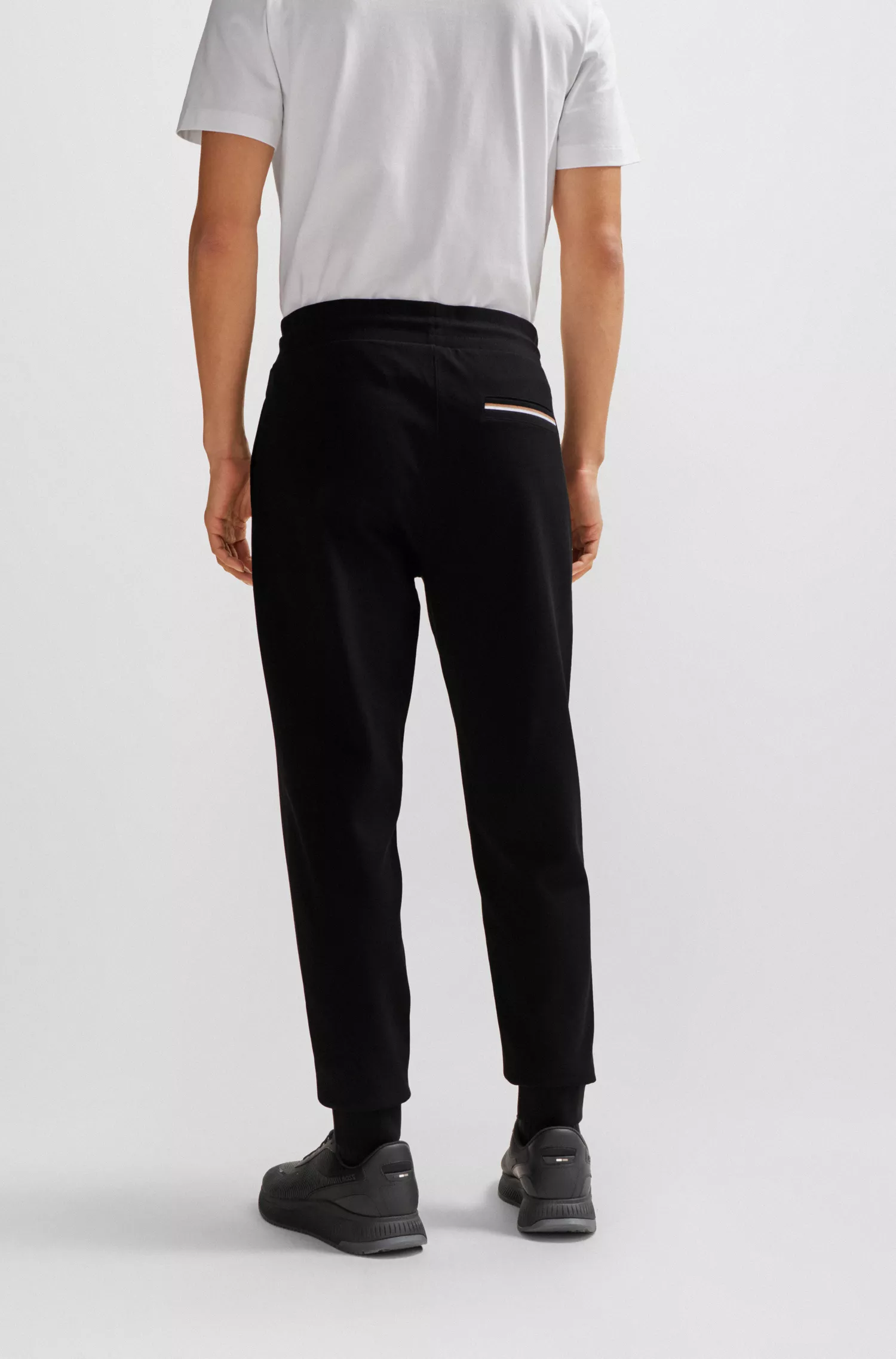 Calça de fato de treino BOSS em mistura de algodão preto com detalhes de riscas características da marca.