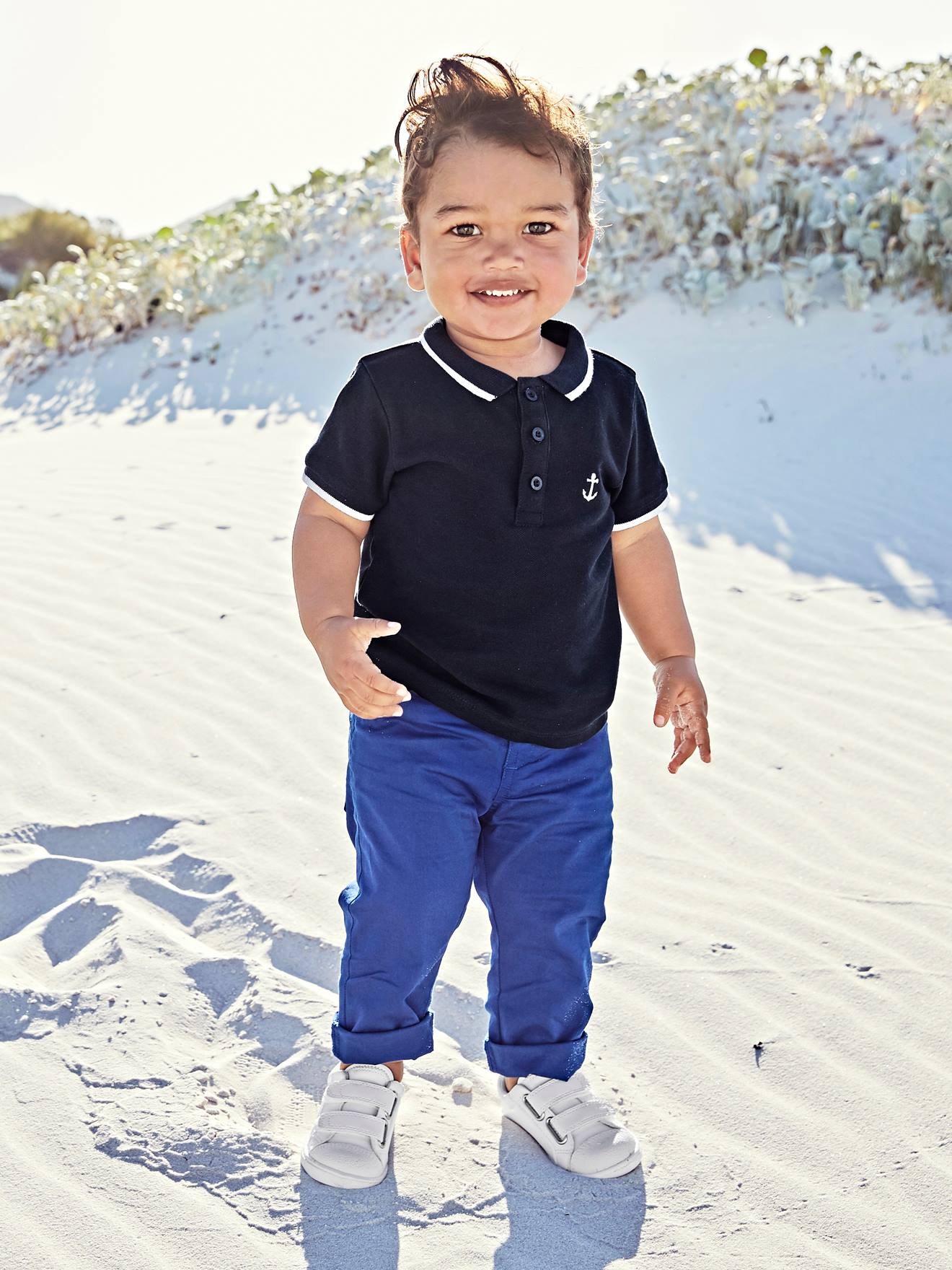 Camisa polo personalizável para bebê menino com bordado liso azul escuro no peito.