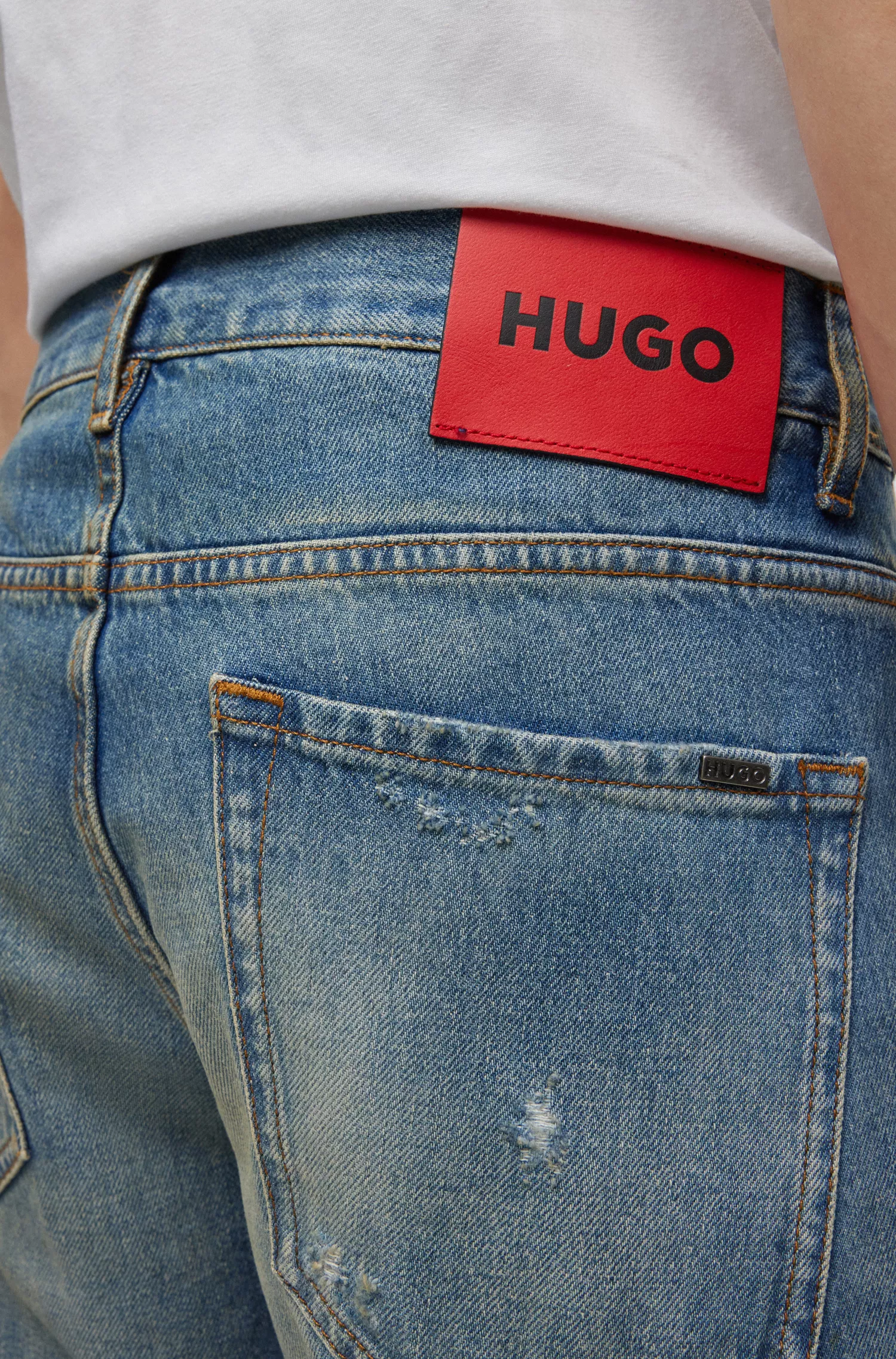 Calça jeans HUGO vermelha, modelagem folgada, em denim azul com lavagem vintage.