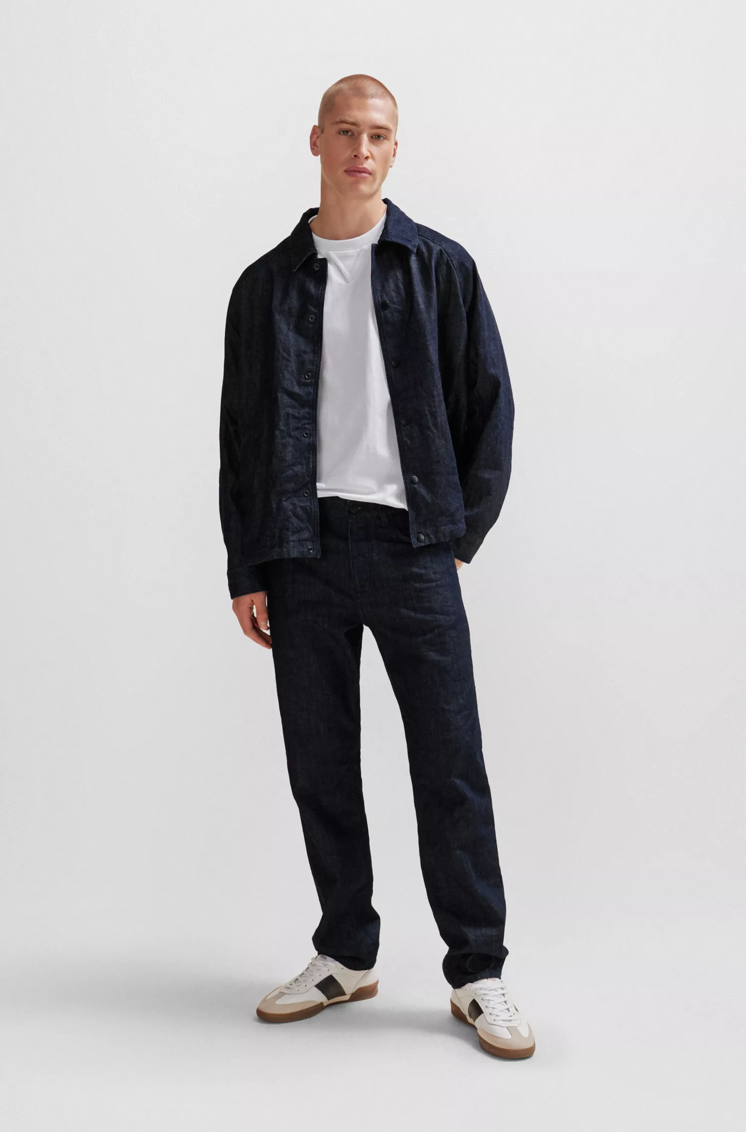 Calça jeans BOSS laranja, modelagem relaxada, em denim azul rígido com efeito amassado.
