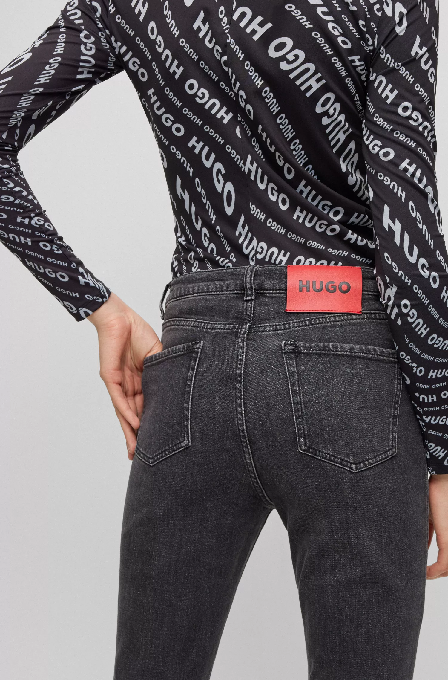 Calça jeans HUGO vermelha, corte slim, em denim stretch preto.