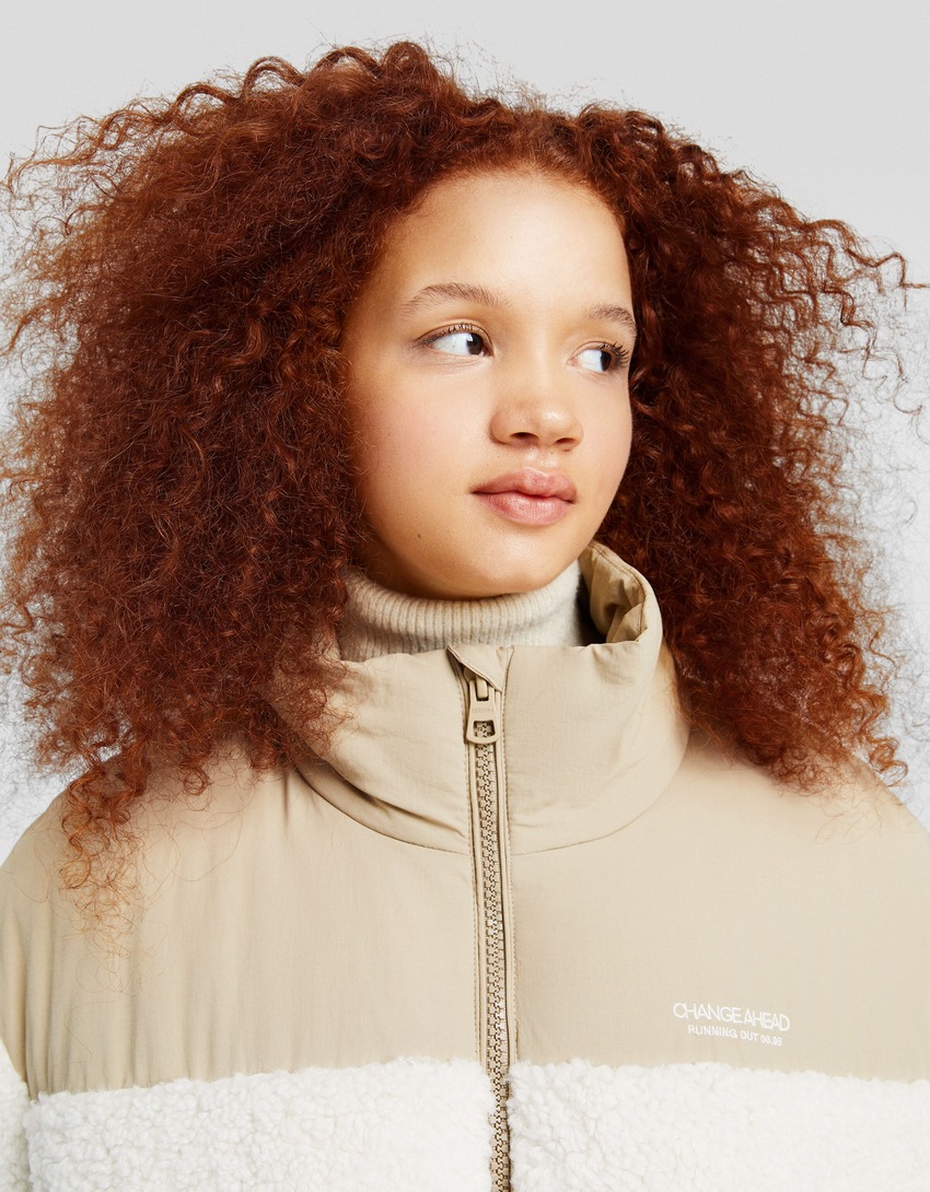 Jaqueta puffer com detalhes contrastantes em imitação de pele de carneiro e nylon.