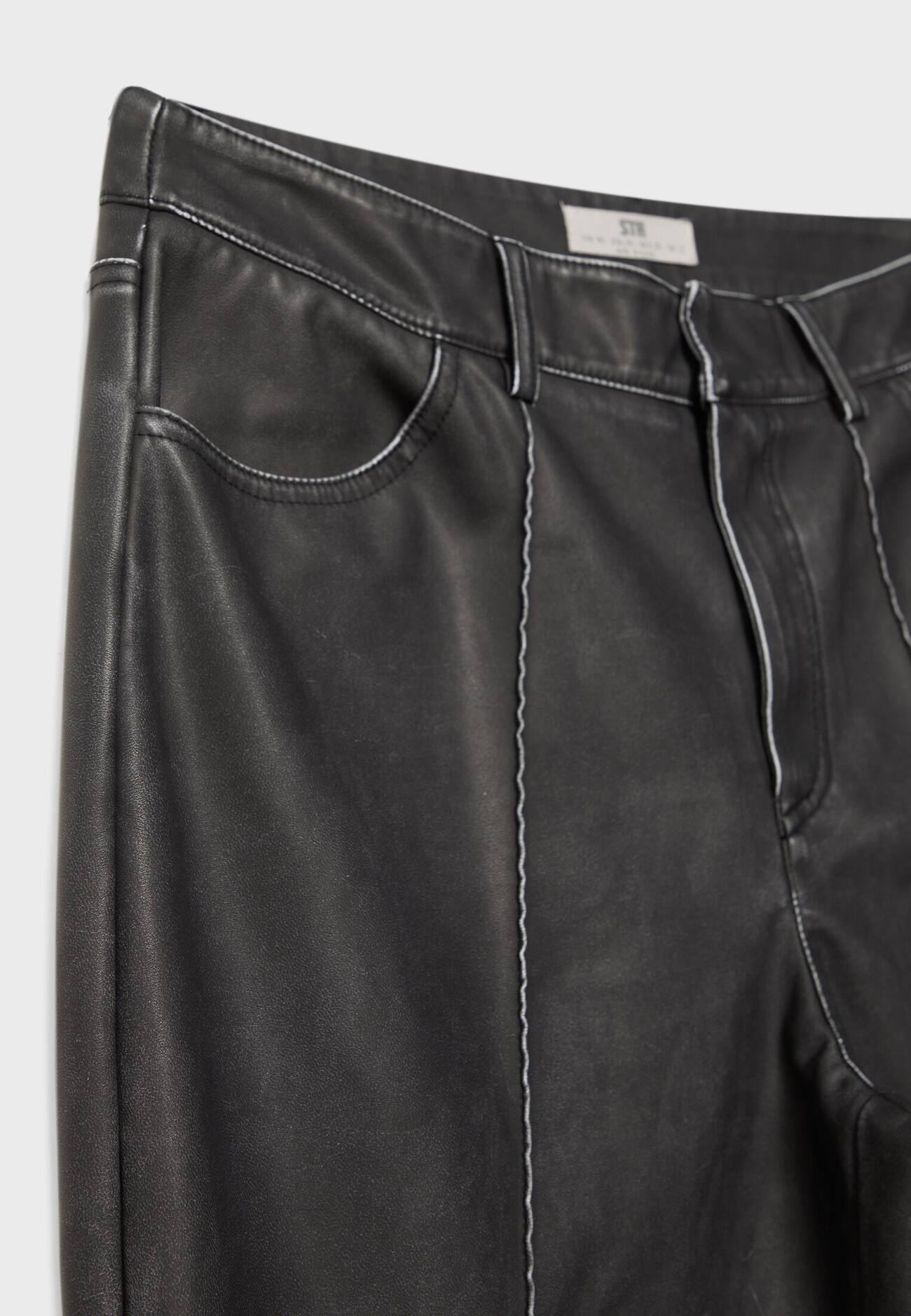 Calça reta com efeito couro e detalhe de costura