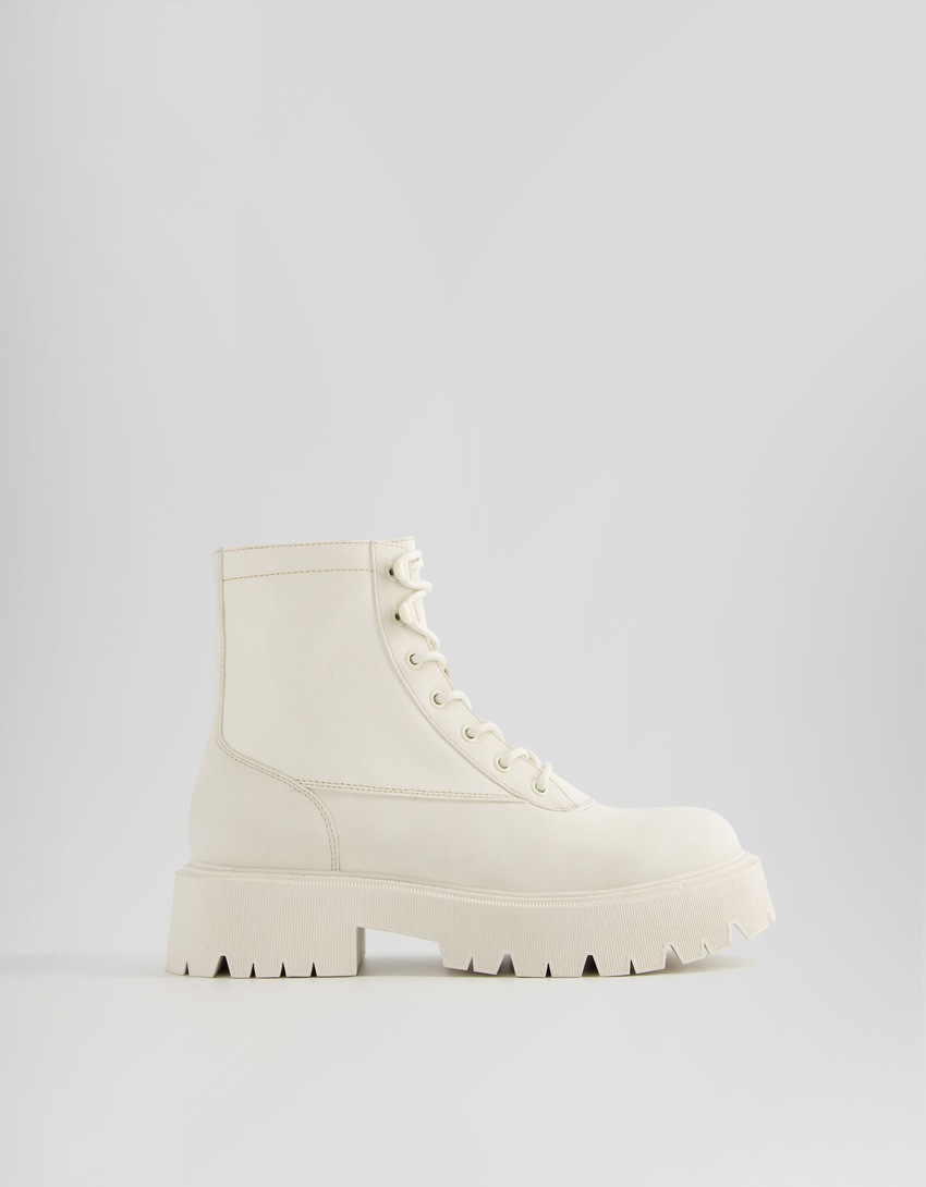 Botas de cano curto com cadarço e modelagem rasteira contrastante