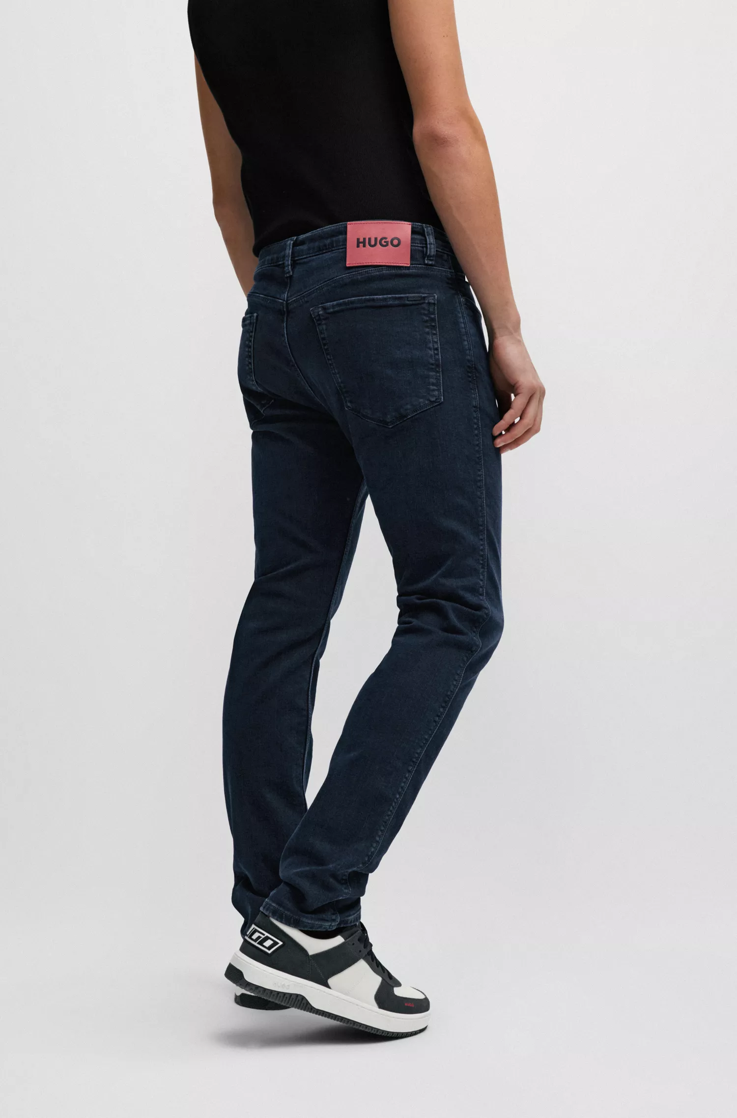 Calça jeans HUGO vermelha, corte slim, em denim stretch azul-preto.