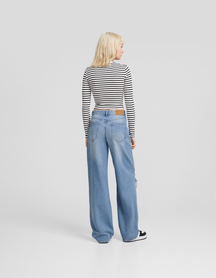 Calça jeans rasgada de perna larga dos anos 90