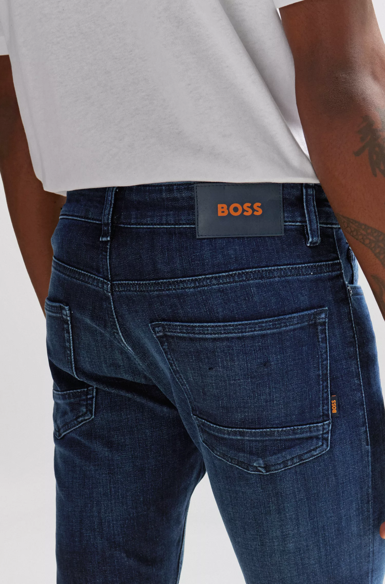 Calça jeans BOSS laranja, corte slim, em denim super elástico azul.