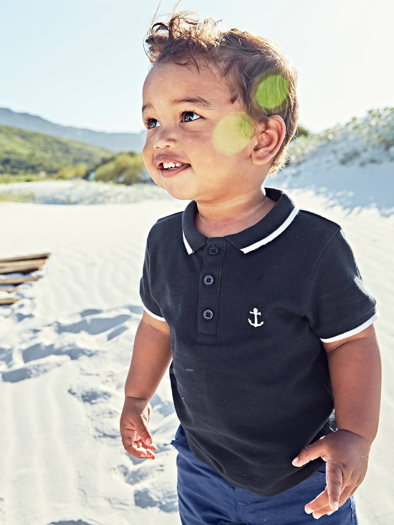 Camisa polo personalizável para bebê menino com bordado liso azul escuro no peito.