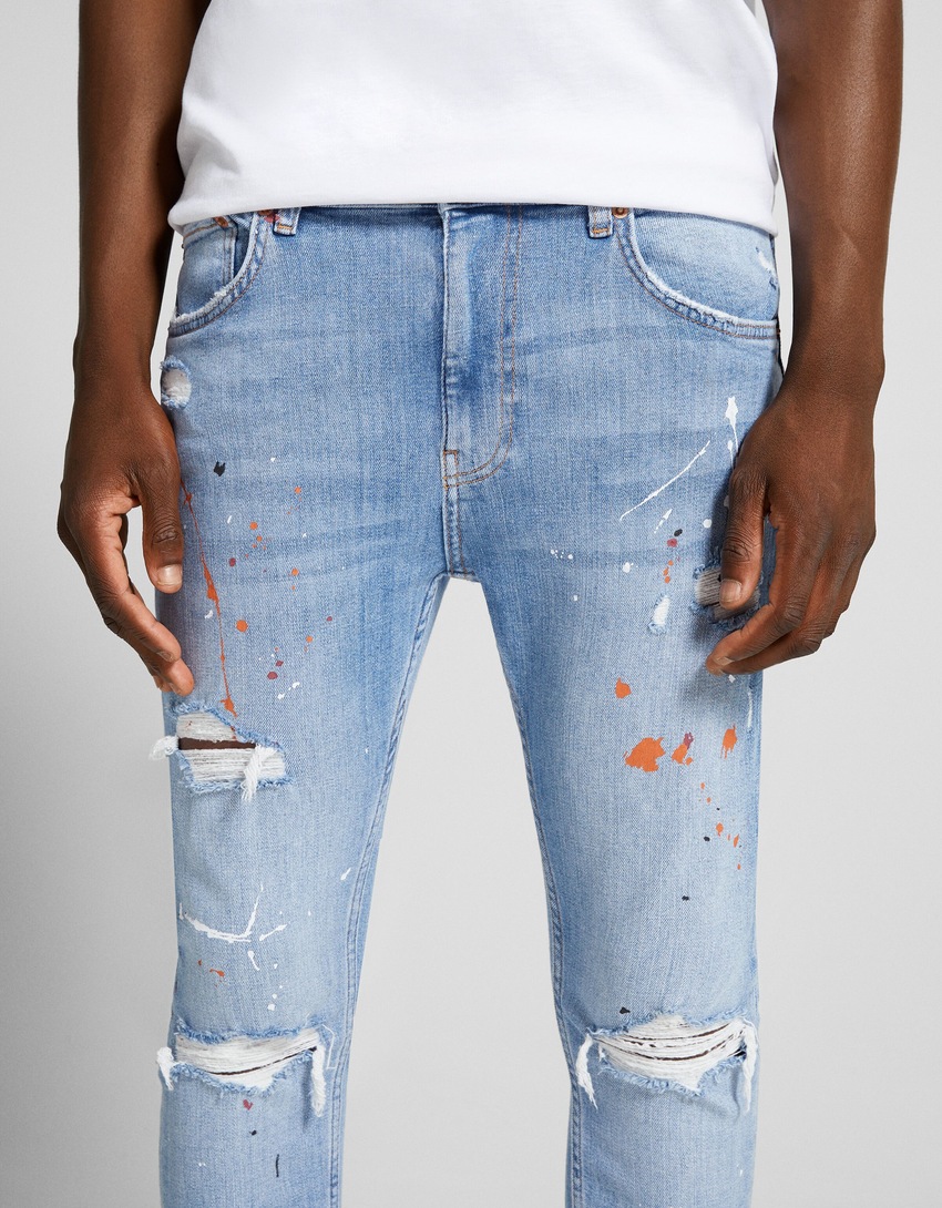 Calça jeans super skinny rasgada com respingos de tinta