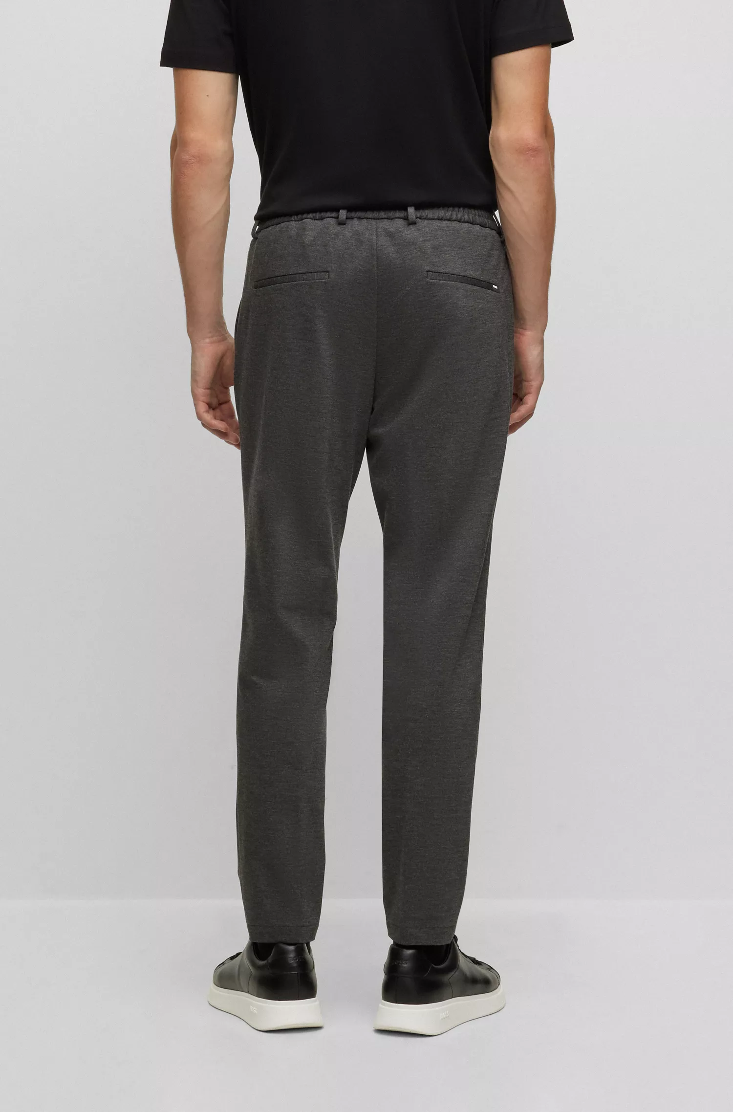 Calça BOSS preta, corte slim, em malha interlock de alta performance com elasticidade.