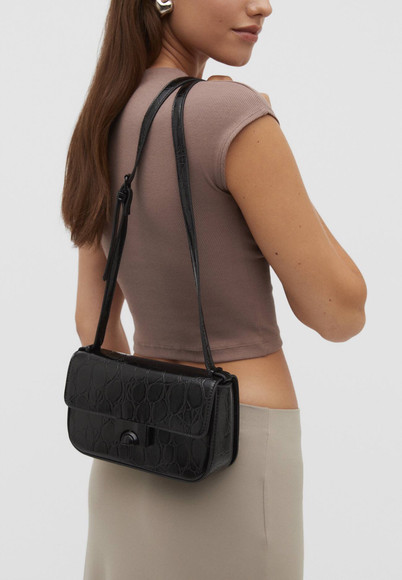 Bolsa transversal com estampa de crocodilo e fecho.