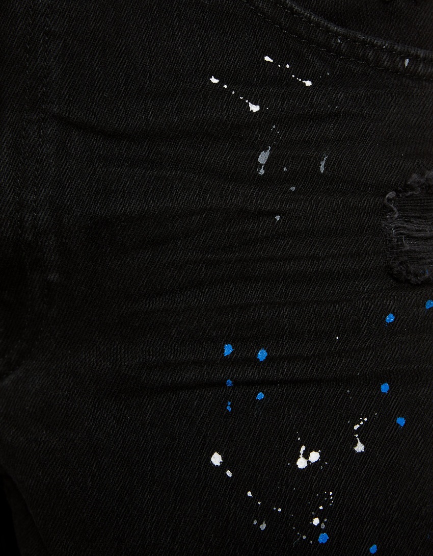 Bermuda jeans rasgada com respingos de tinta