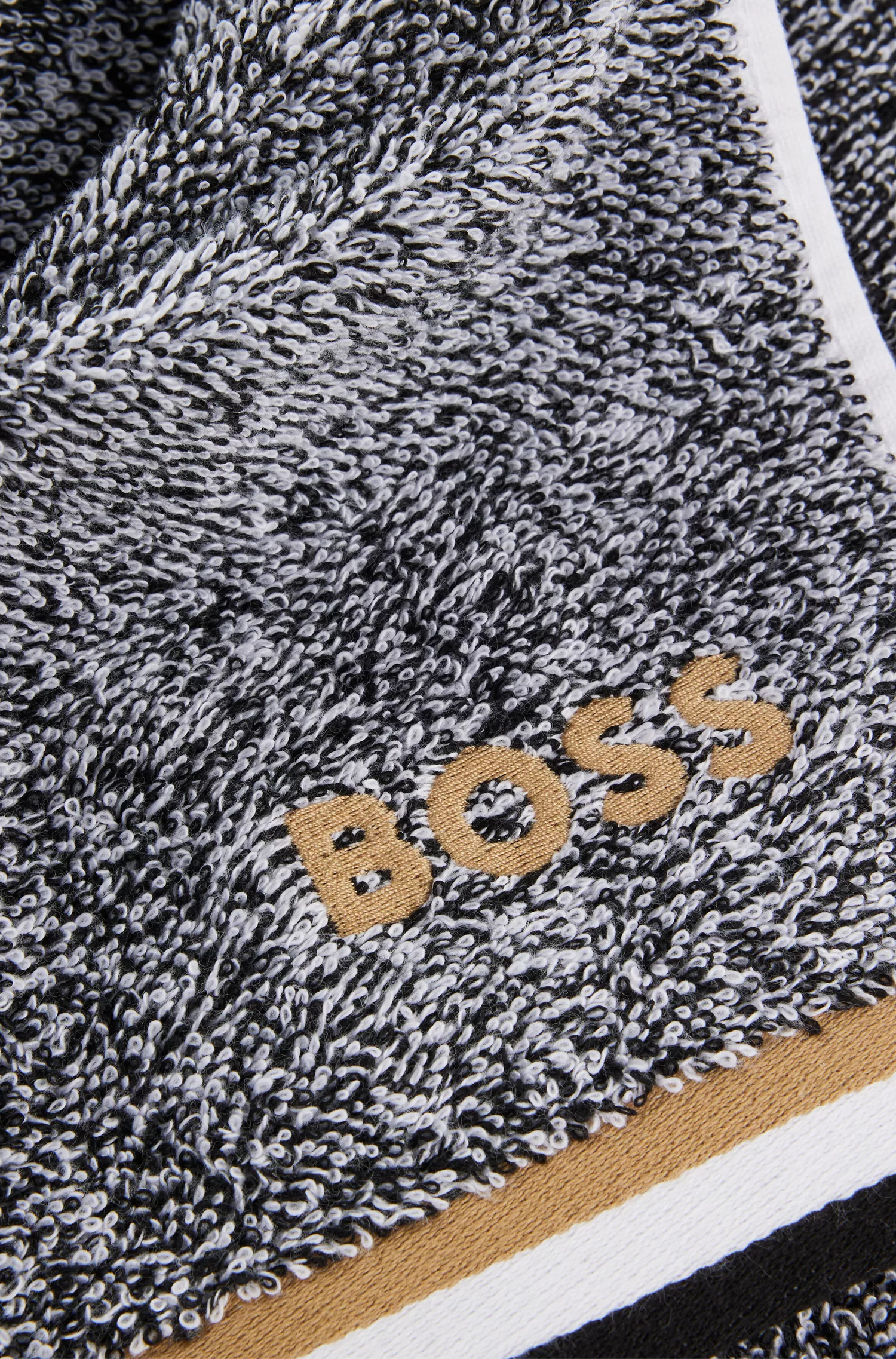 Tapete de banho BOSS em jacquard de algodão preto com listras características.