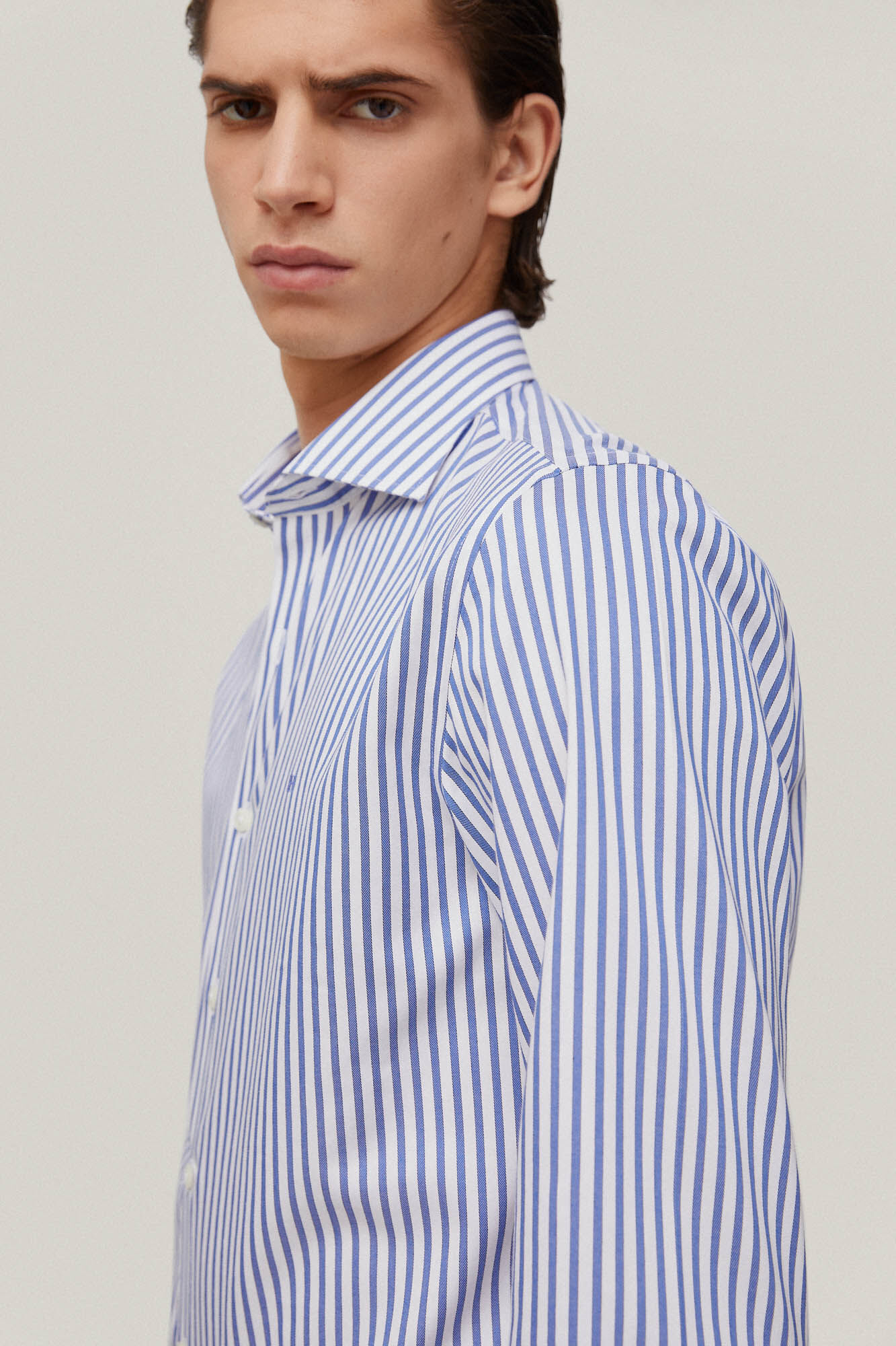Camisa social listrada, azul, que não precisa passar e é resistente a manchas.