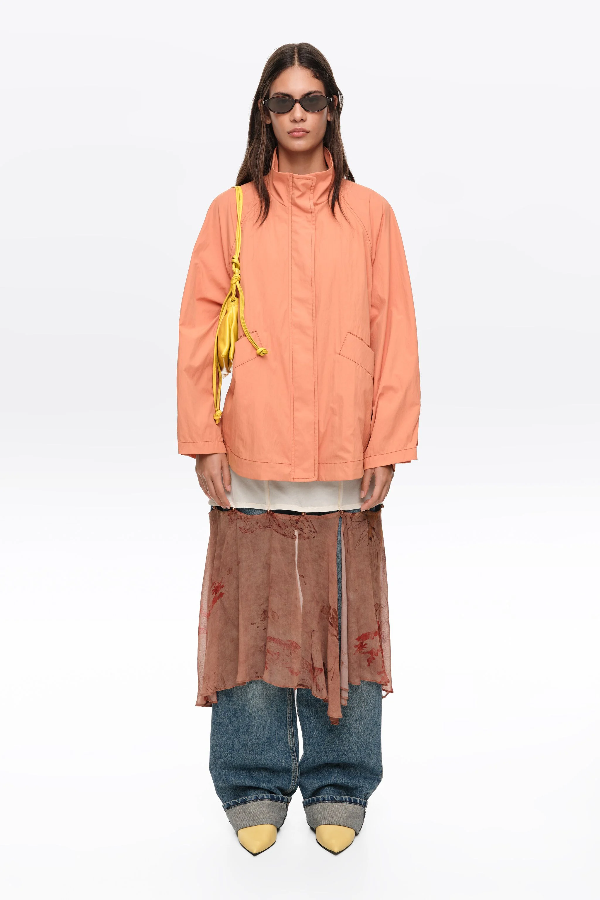 Trench coat curto, laranja, fluido, com gola alta.