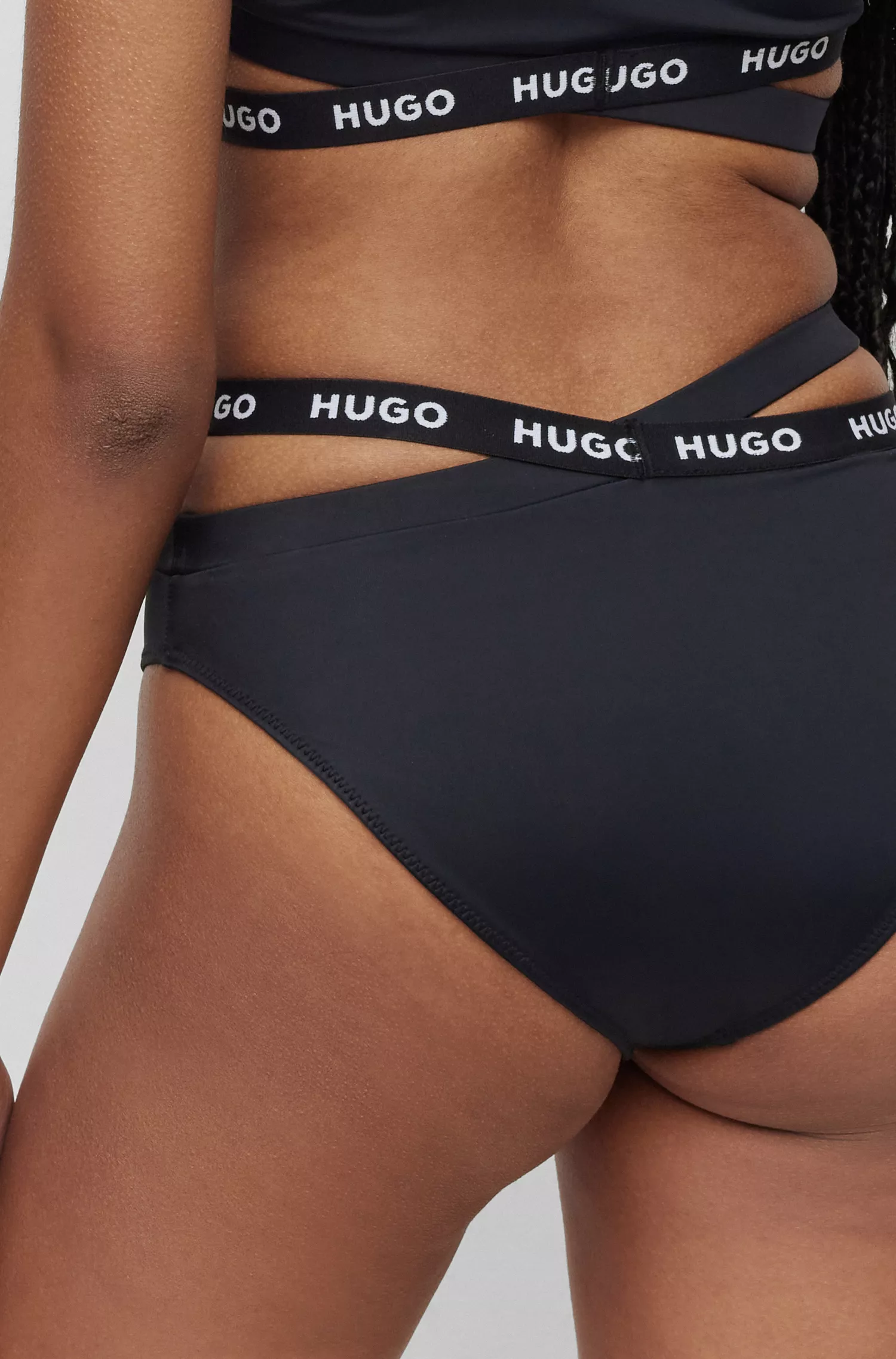 Calcinha de biquíni esportiva HUGO vermelha com fita da marca e detalhes vazados.