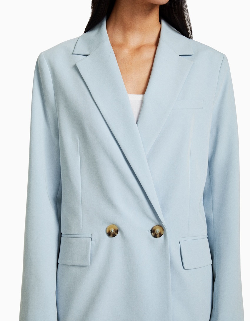 Blazer feminino de corte regular e abotoamento duplo.