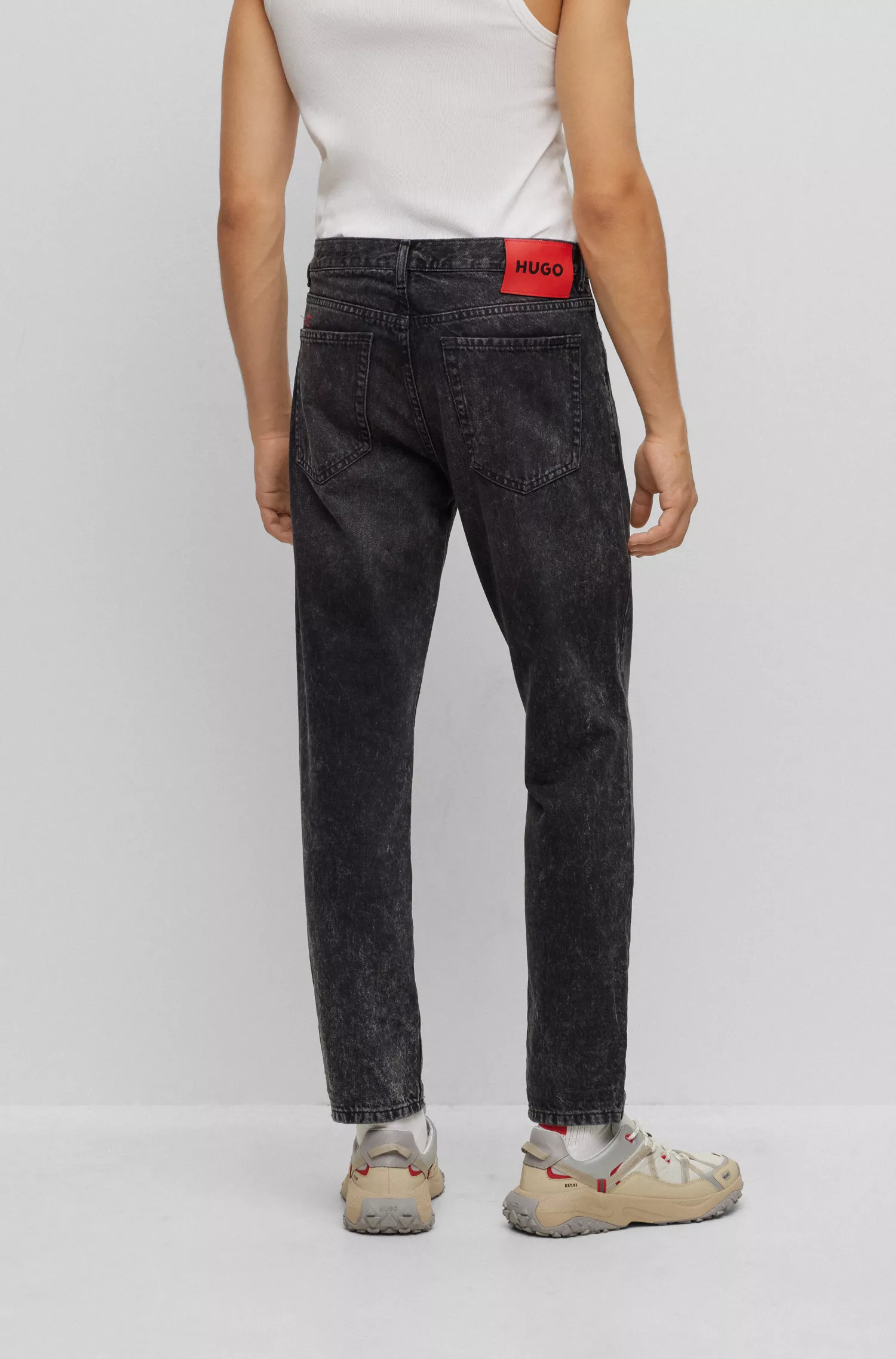 Calça jeans HUGO vermelha, corte afunilado, em denim rígido preto.