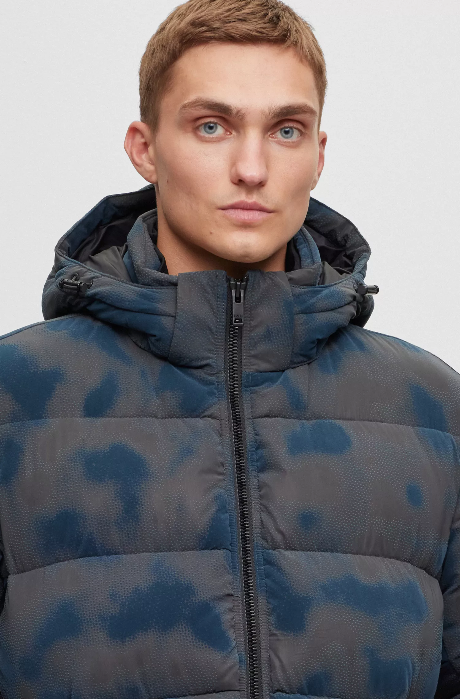 Jaqueta puffer BOSS laranja, modelagem relaxada e estampa flocada da estação.
