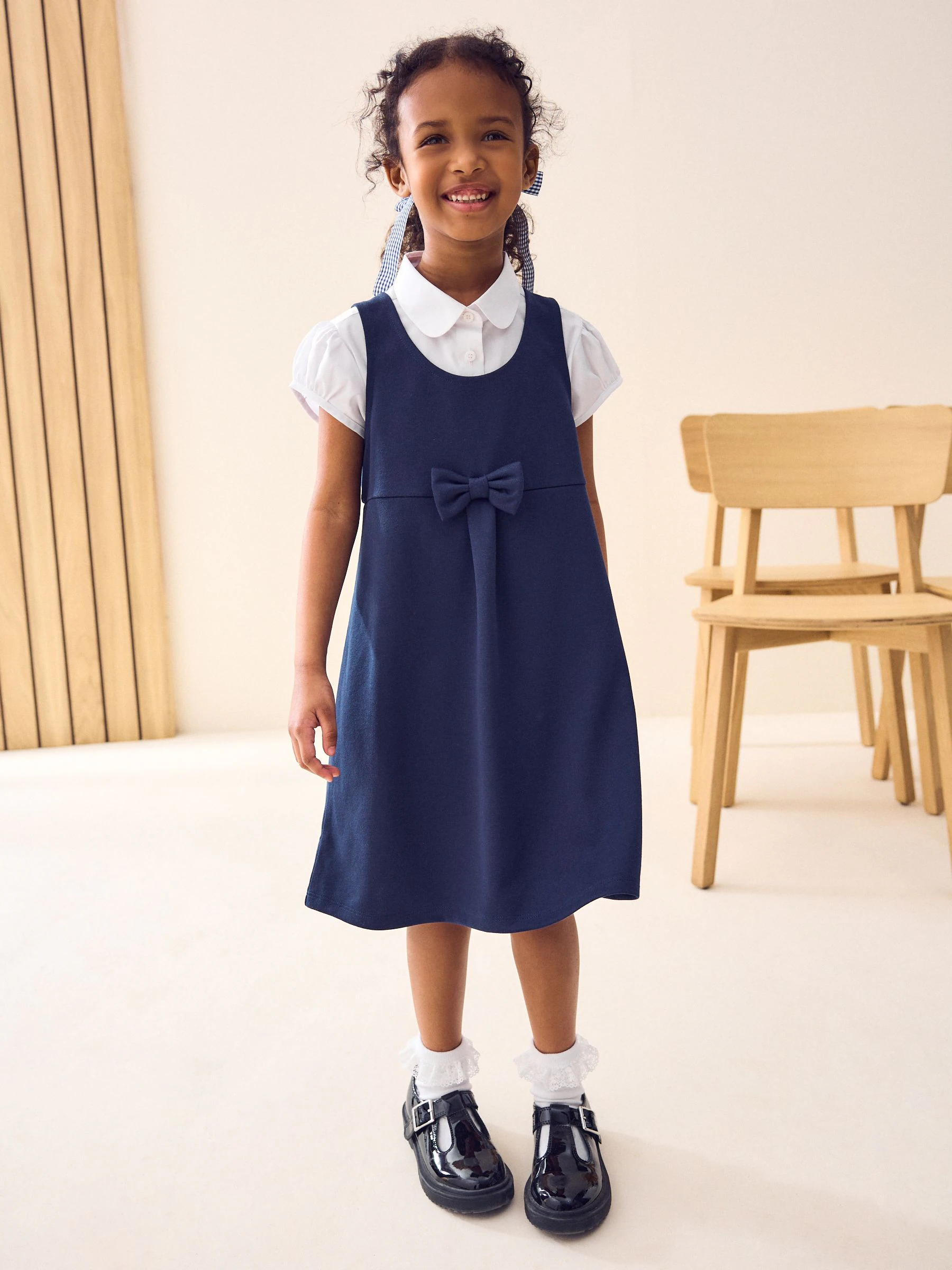 Marineblauw - Jersey stretch schoolovergooier met strik (3-16 jr)