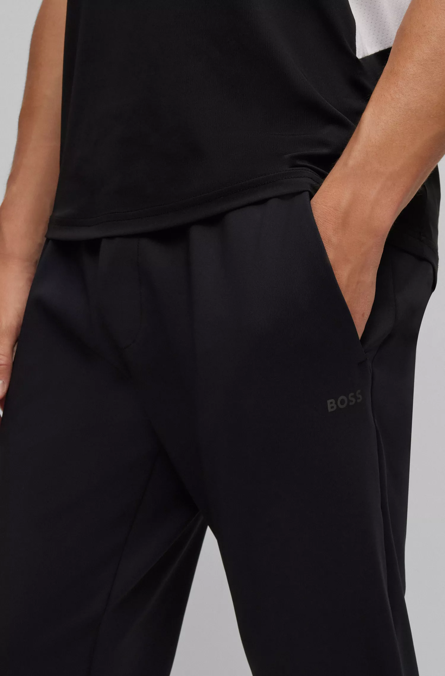 Calça de fato de treino BOSS verde com punhos, em tecido elástico para atividades físicas.