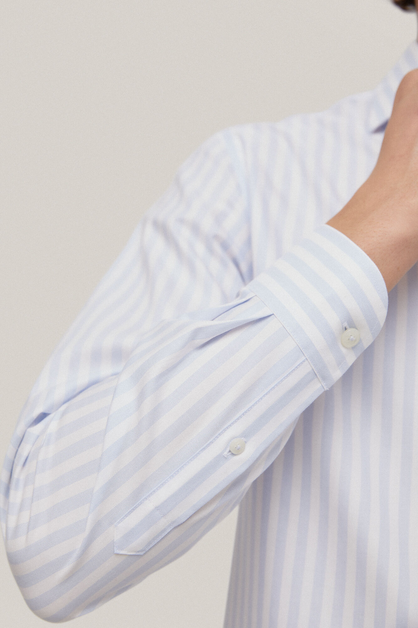 Camisa social listrada, azul, que não precisa passar e é resistente a manchas.