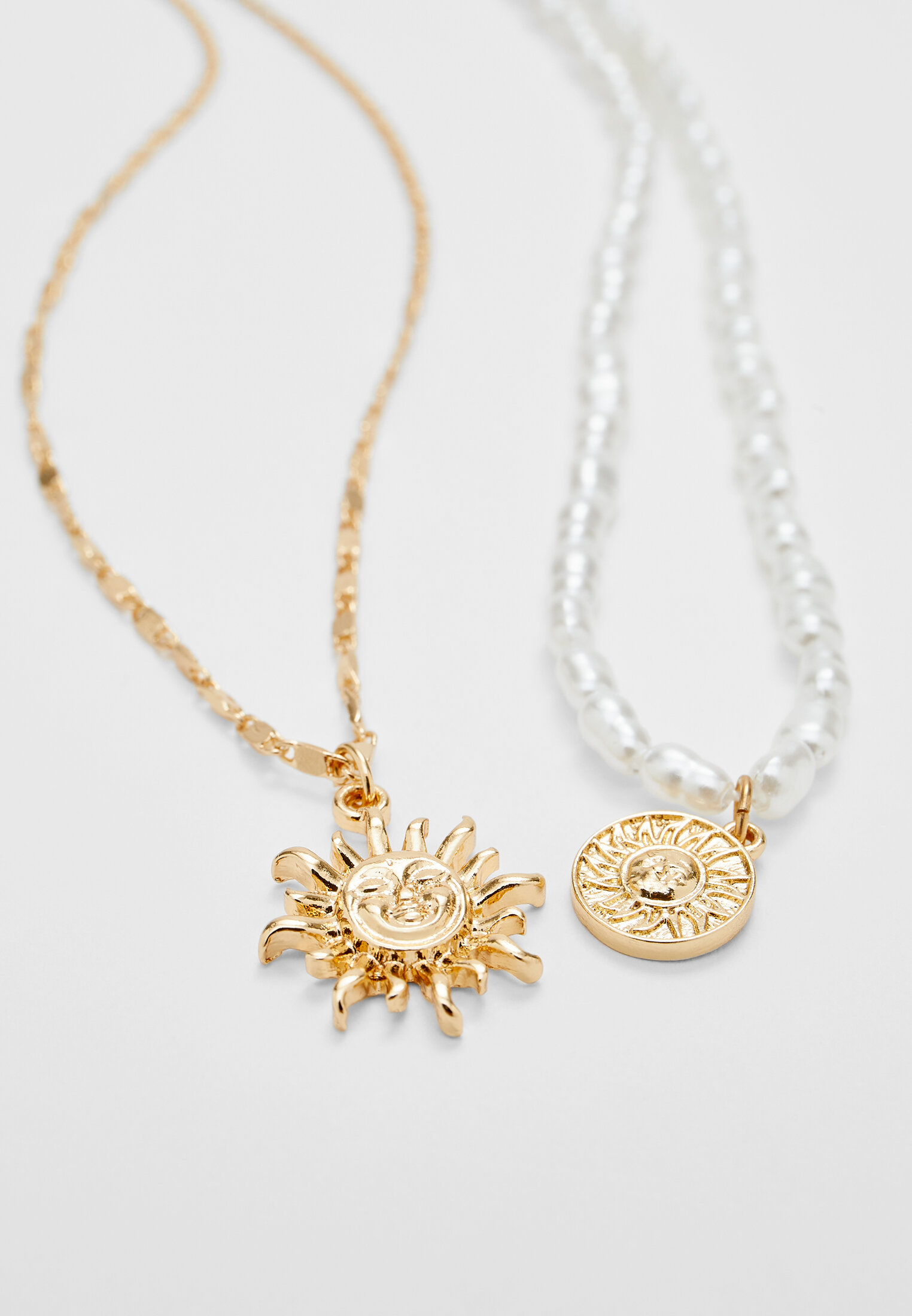 Conjunto de 4 colares com pingente de sol e pérolas artificiais.