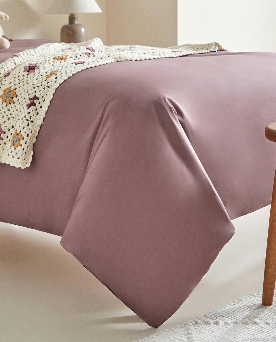Lençol de algodão infantil com elástico e costura decorativa.