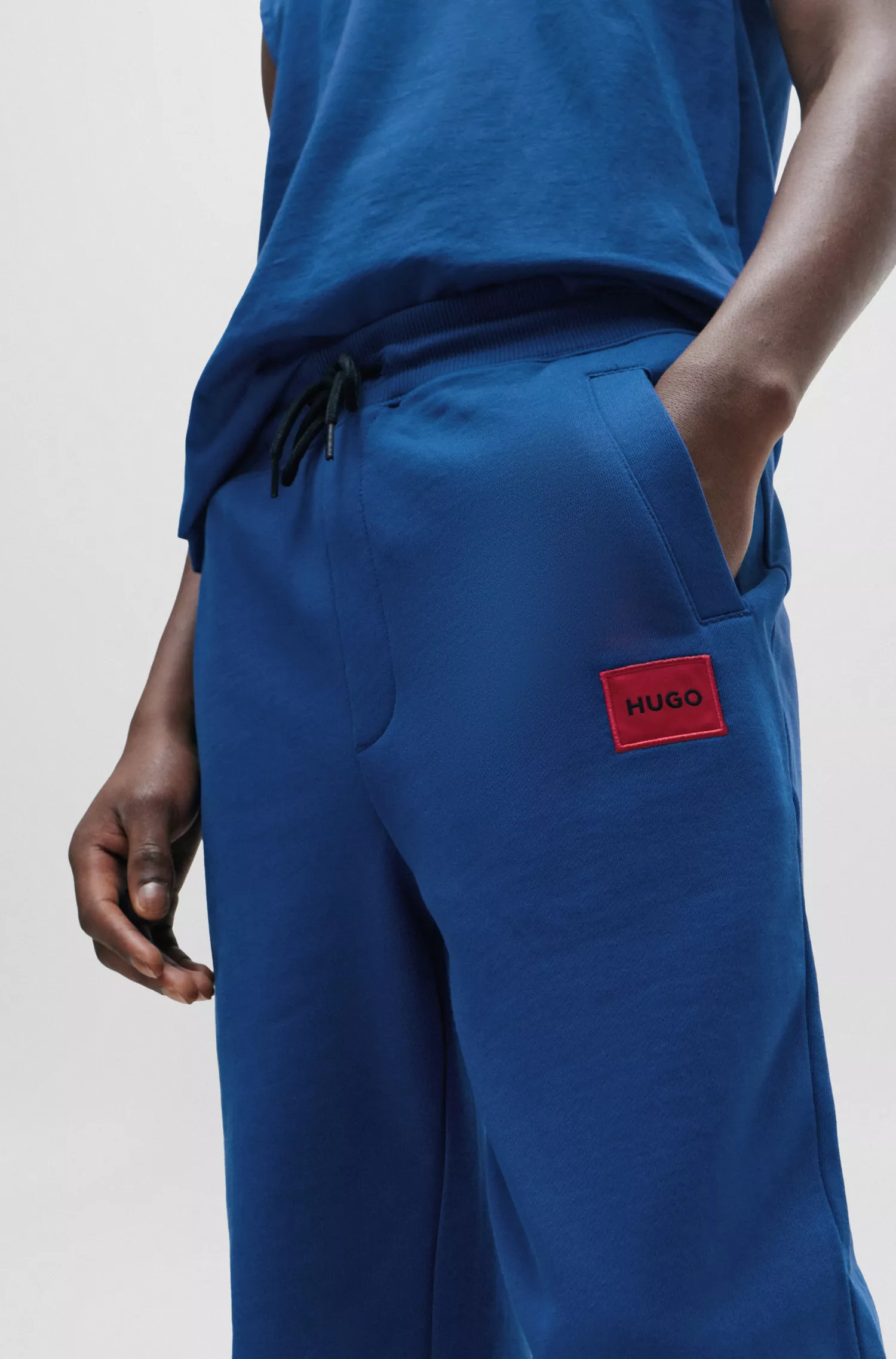 Calça de fato de treino HUGO em tecido atoalhado de algodão vermelho com etiqueta vermelha com o logótipo.