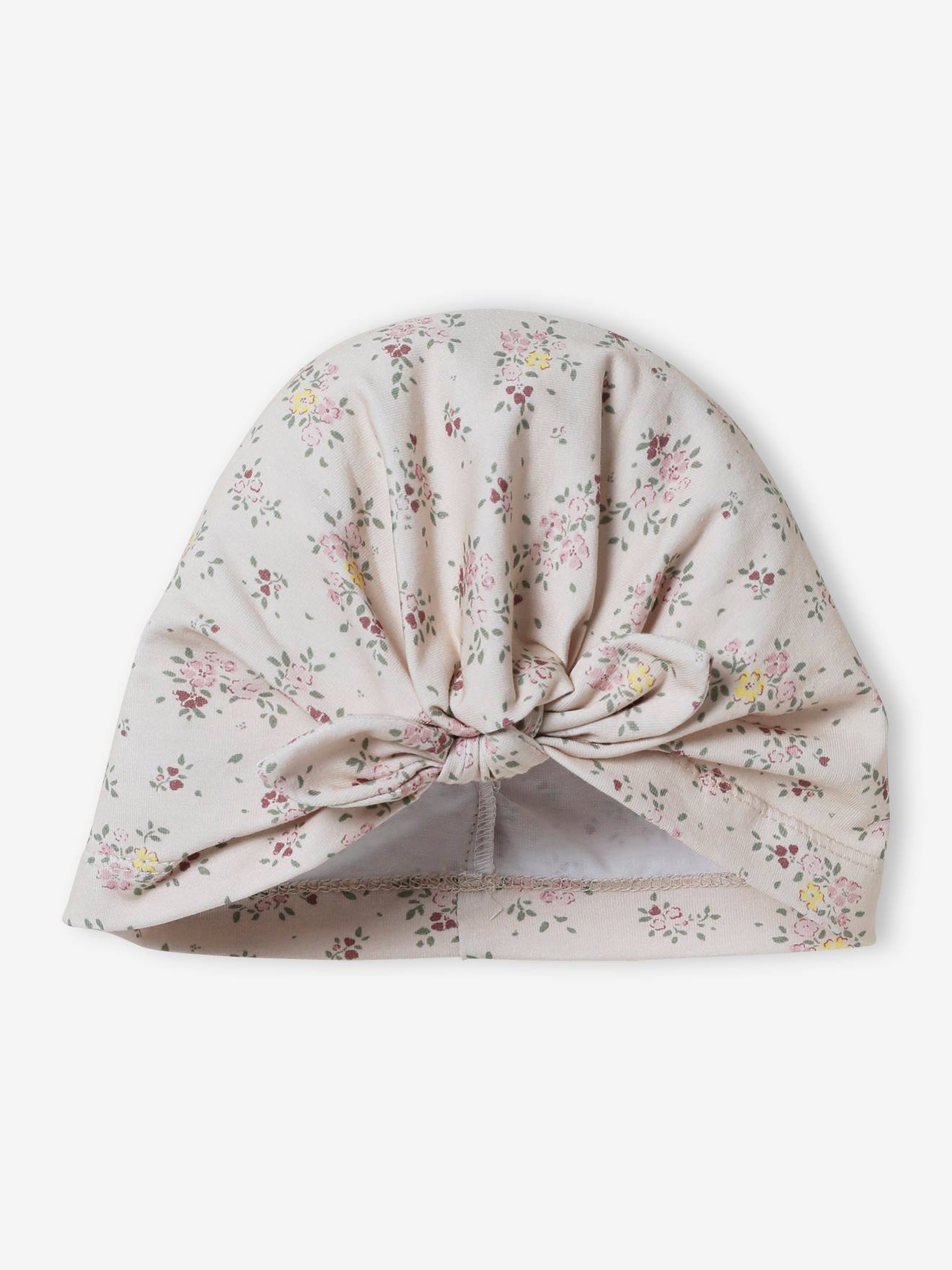 Touca infantil bege de tricô estilo turbante com estampa.
