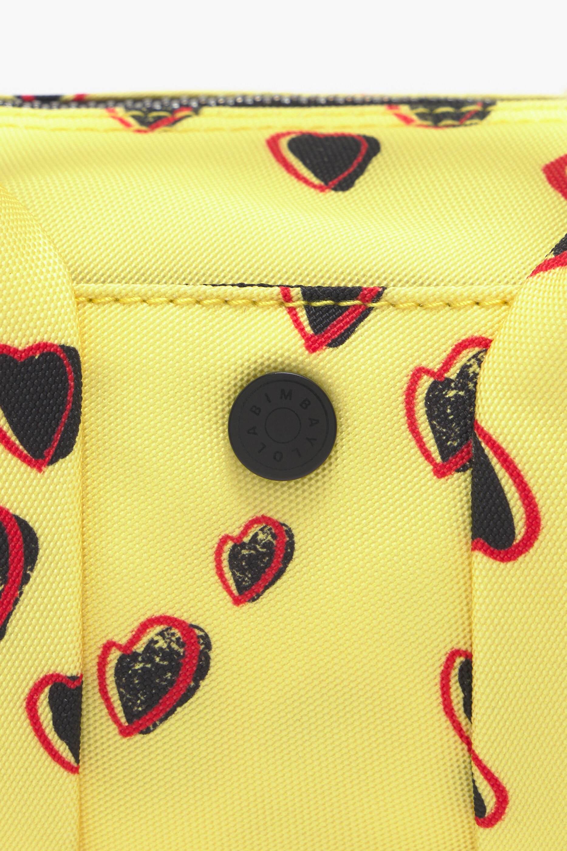 Bolsa cilíndrica de nylon tamanho XS com estampa de pequenos corações, amarela.