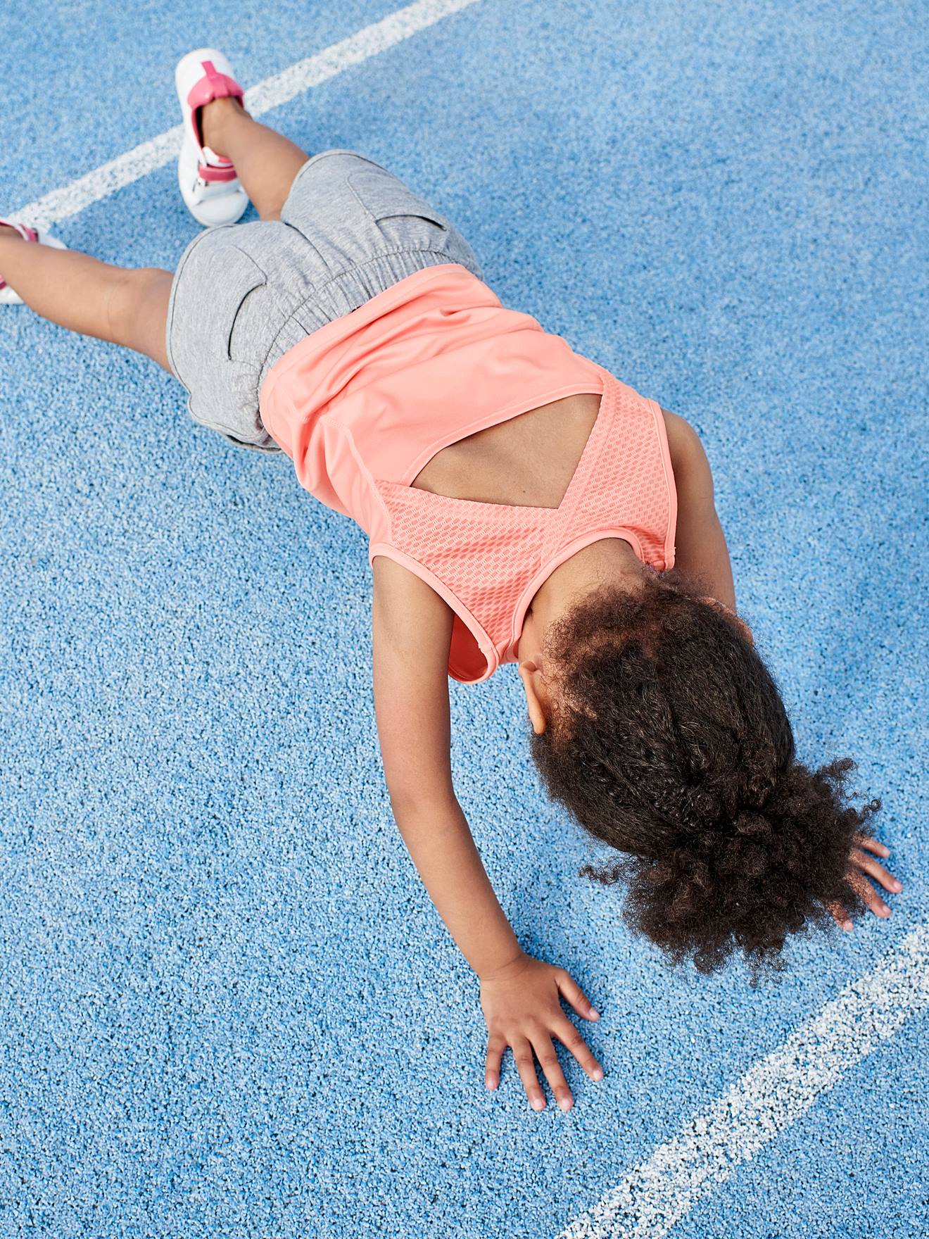 Regata esportiva lisa rosa claro para meninas com letras e motivos iridescentes.