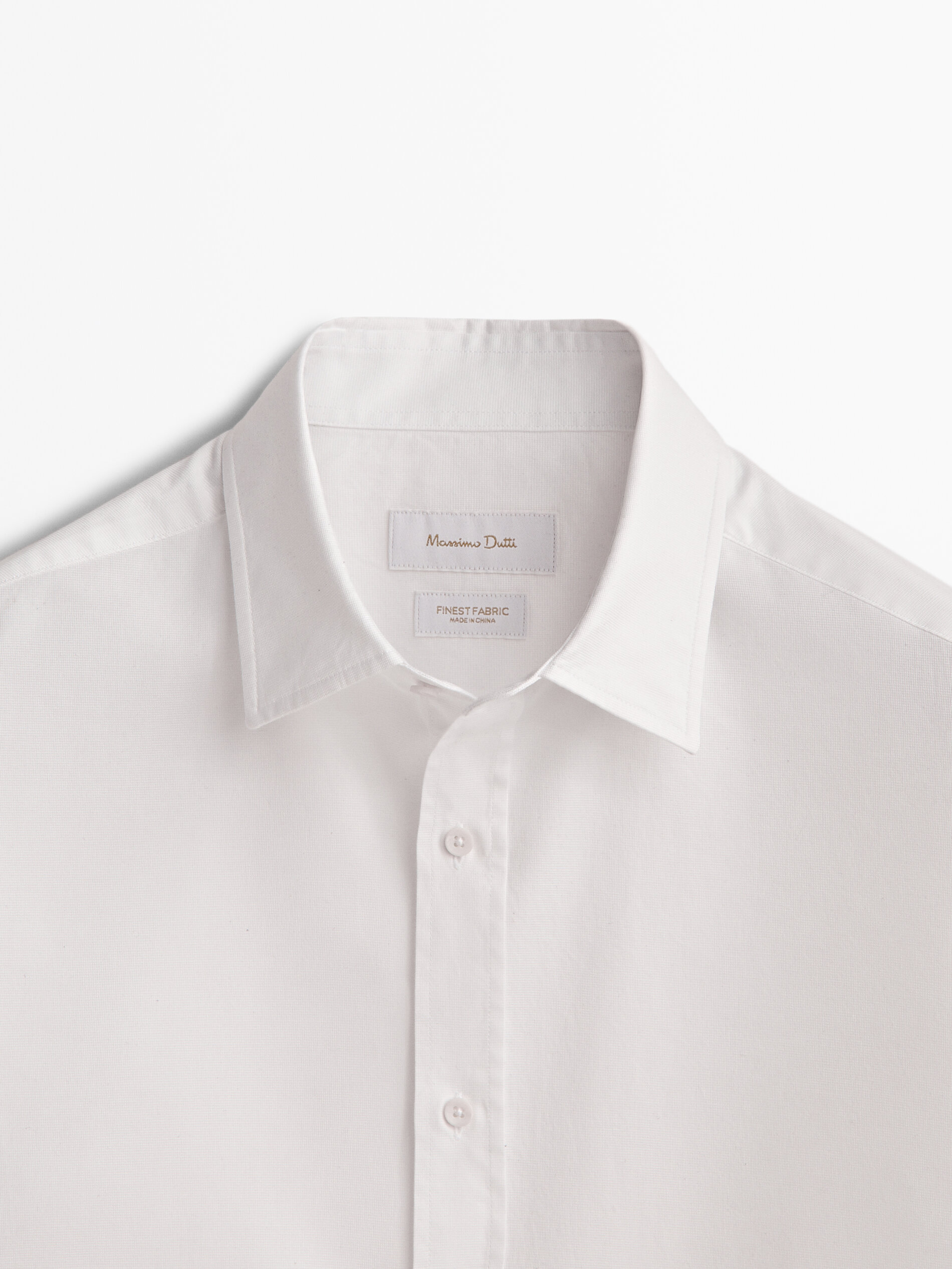 Camisa branca de algodão com microtextura e modelagem regular.