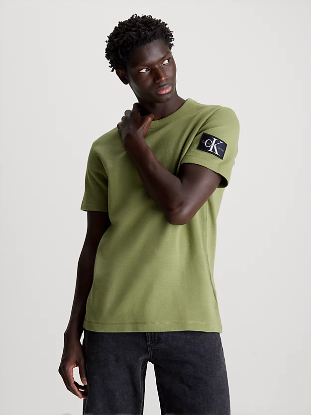Camiseta de algodão com textura alveolar e modelagem slim, com brasão.