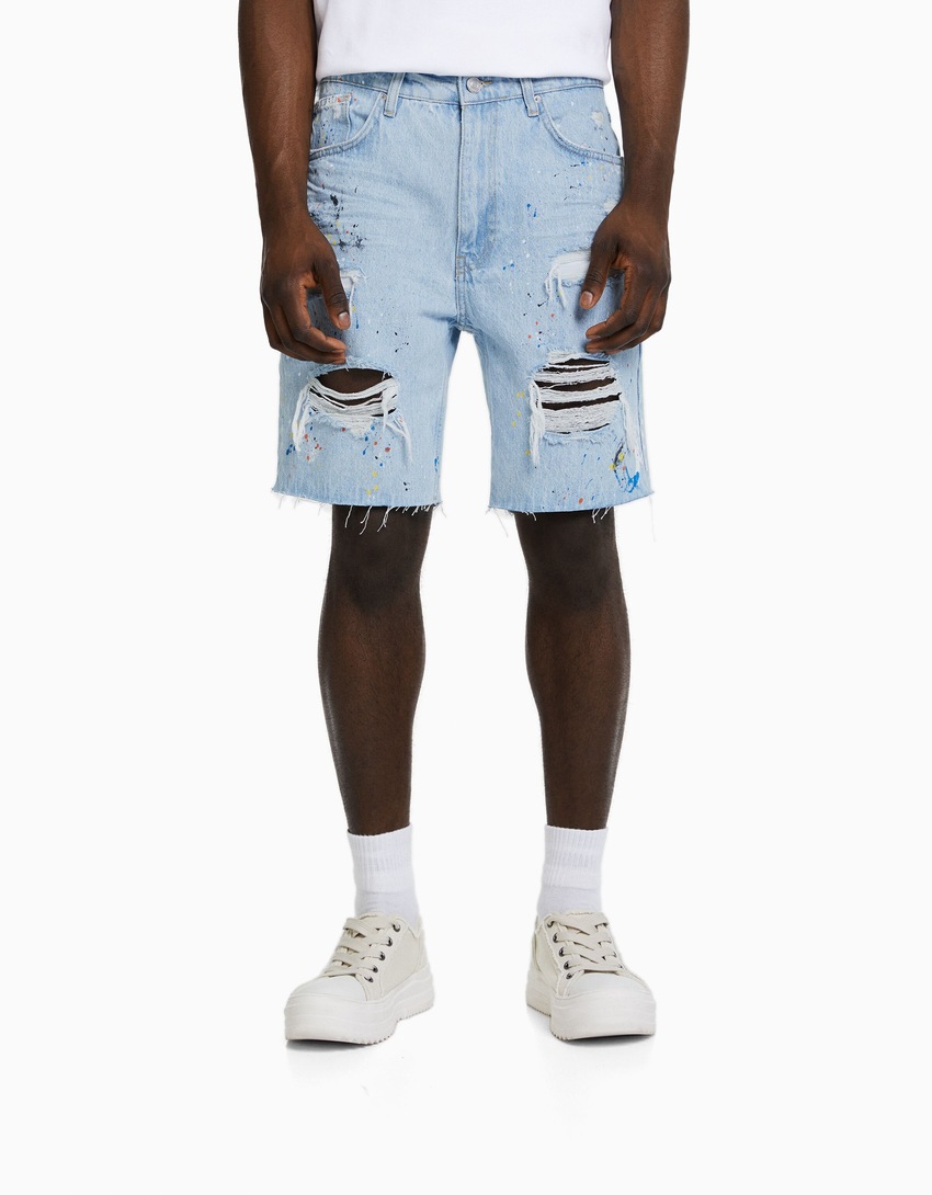 Bermuda jeans rasgada com respingos de tinta