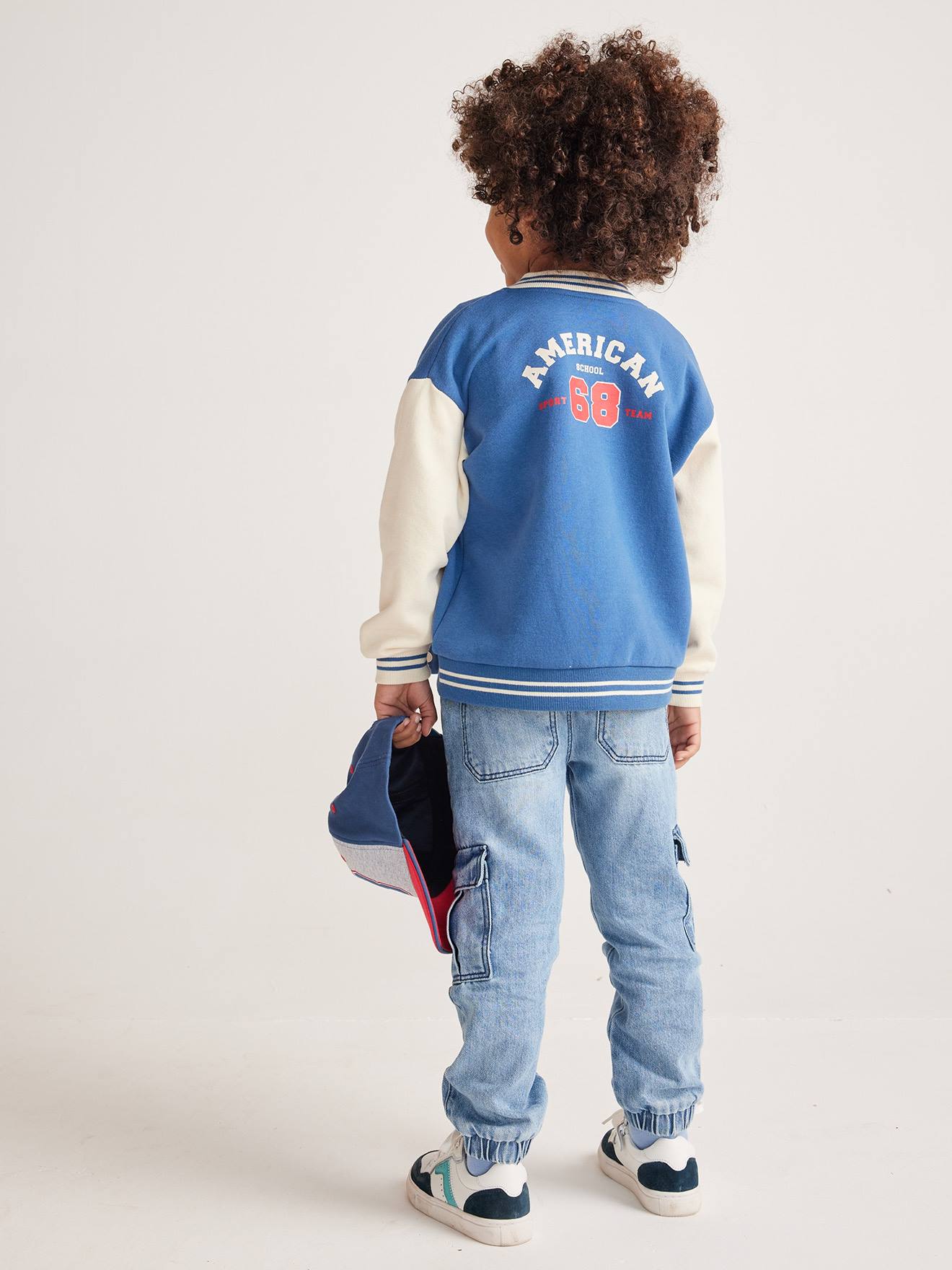 Moletom universitário azul infantil estilo teddy com botões de pressão na frente.
