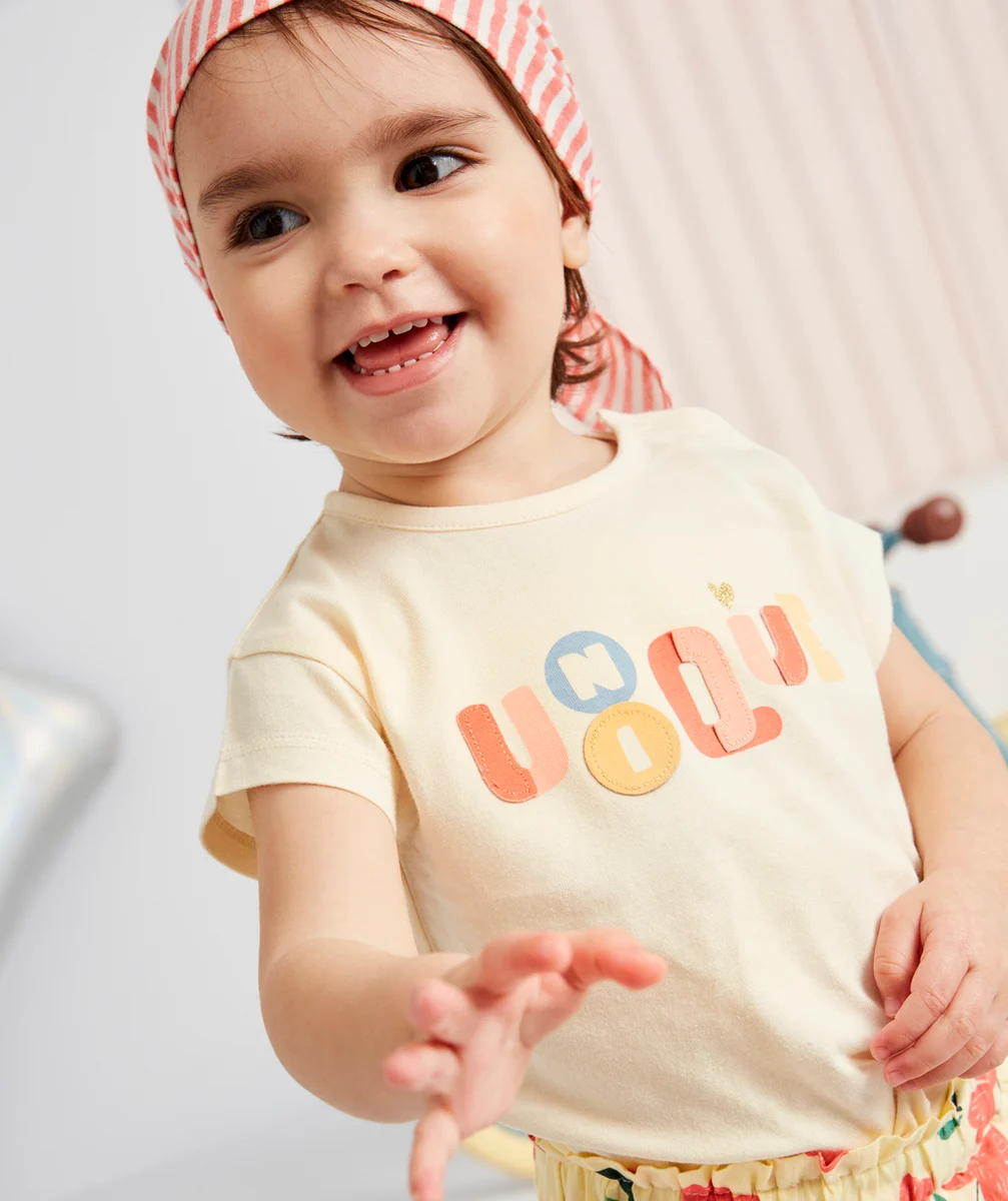 T-SHIRT BÉBÉ FILLE EN COTON BIO ÉCRU AVEC MESSAGE COLORÉ