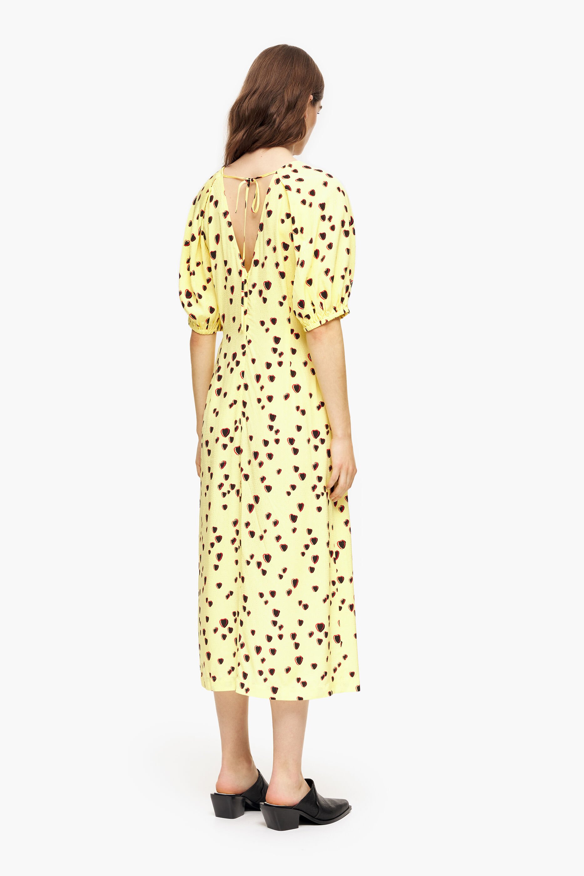Vestido midi evasê com estampa de pequenos corações em amarelo.