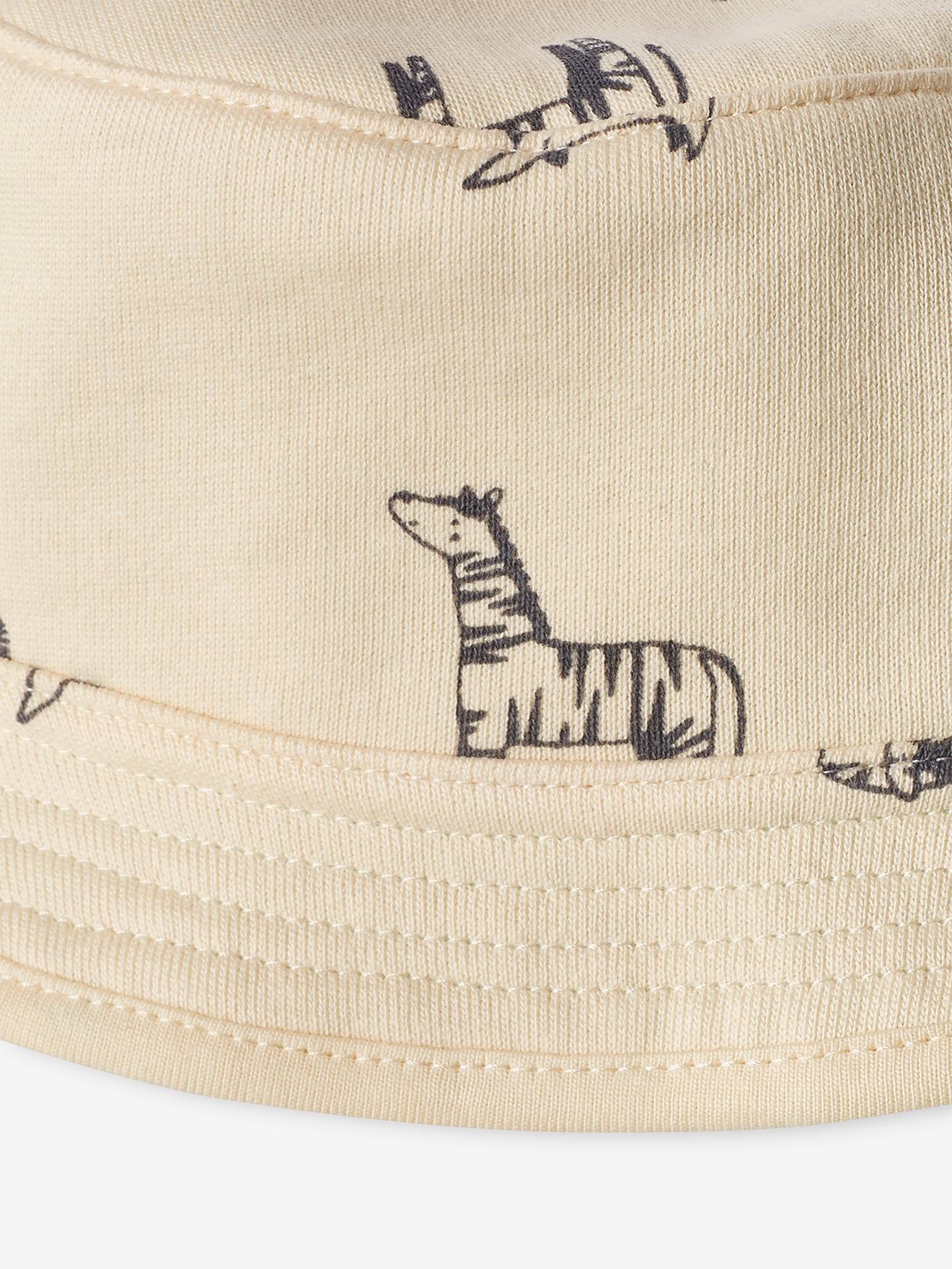 Conjunto para recém-nascido: gorro chanel, body e jardineira azul-escura estampada.