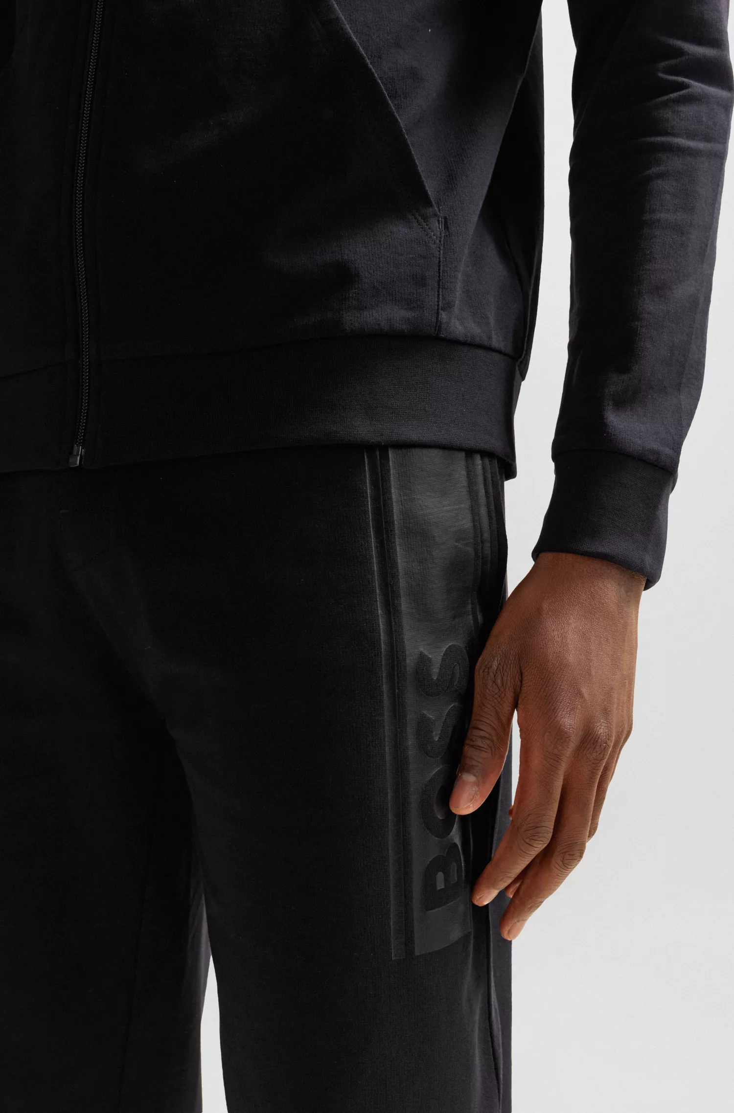 Calça de fato de treino BOSS preta com punhos, em tecido felpudo francês e estampa com o logótipo.