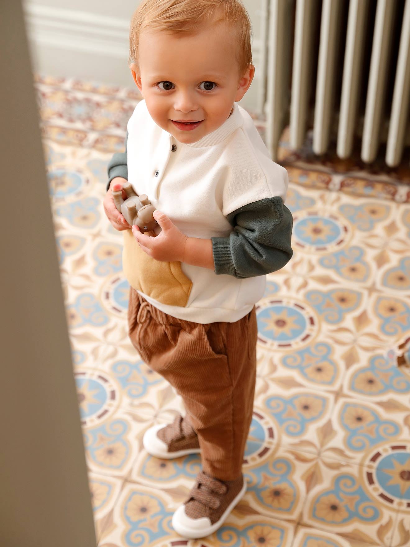 O conjunto para bebê inclui um moletom de lã e calças de veludo, em branco claro liso com estampas.