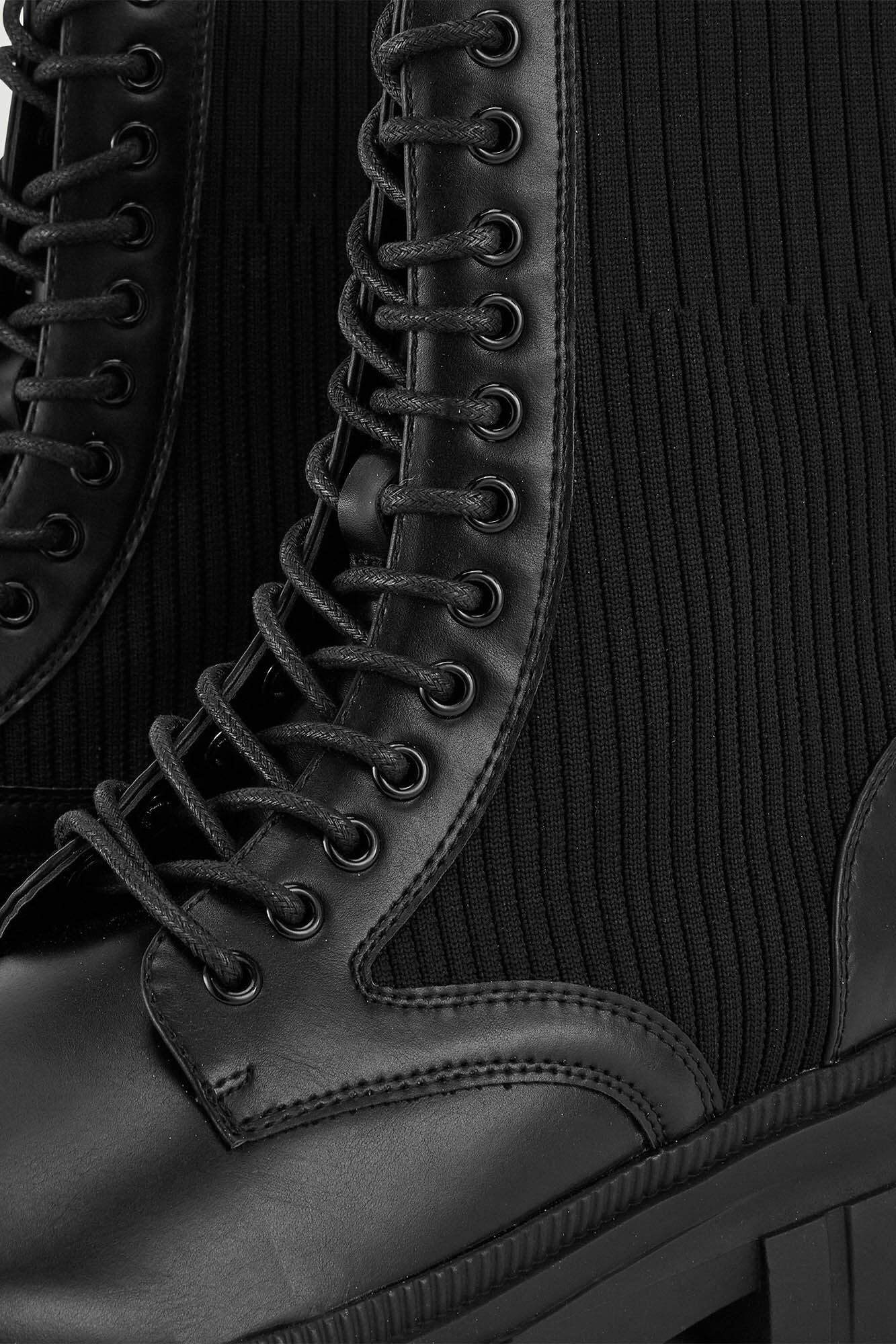 Botas de cano curto em imitação de couro com cadarços e sola serrilhada.
