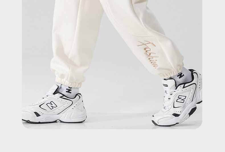 Dandyluxe - Cropped harem-joggingbroek met trekkoord en geborduurde letters